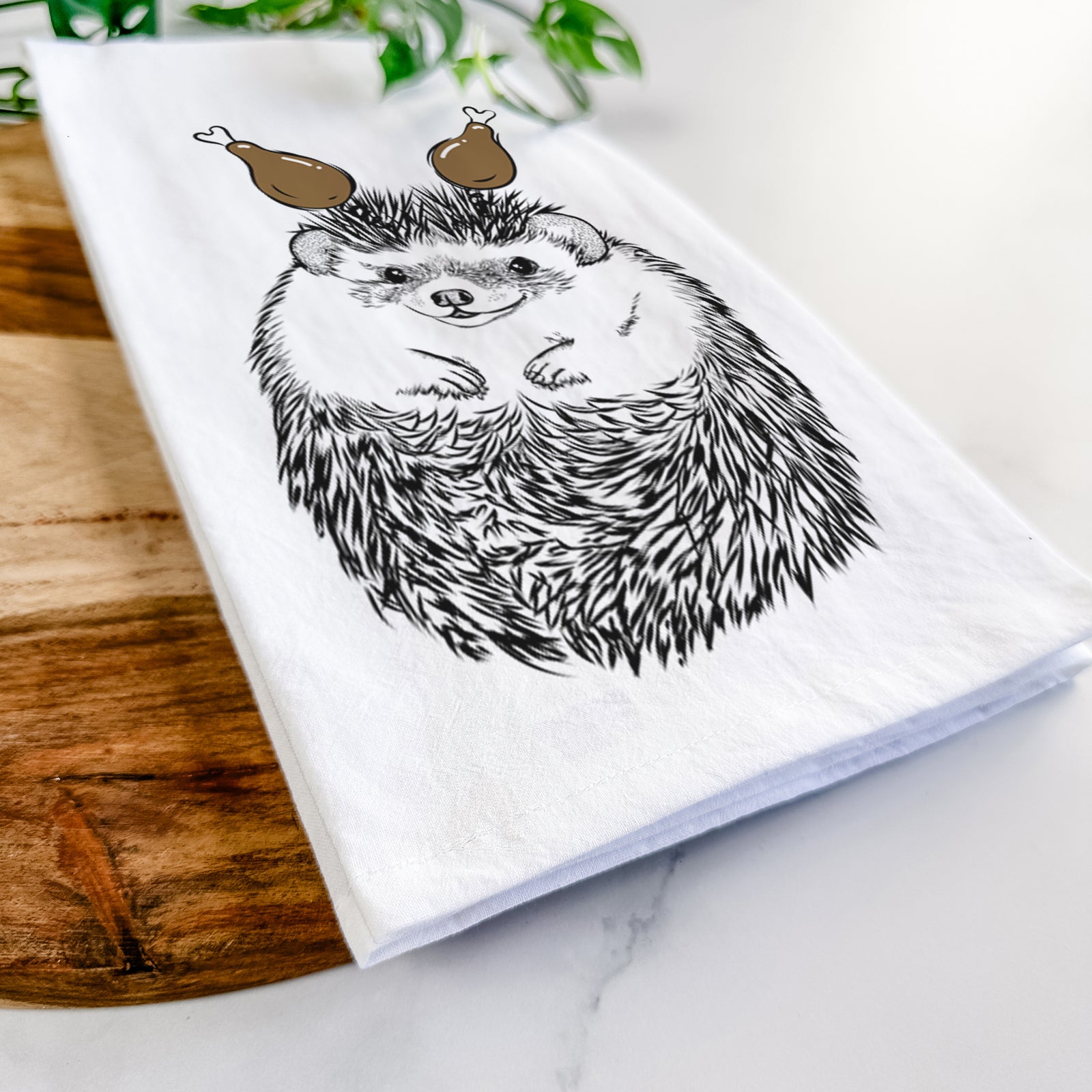 Hand-drawn sketch of Sid the Hedgehog with a Thanksgiving turkey headpiece on a tea towel