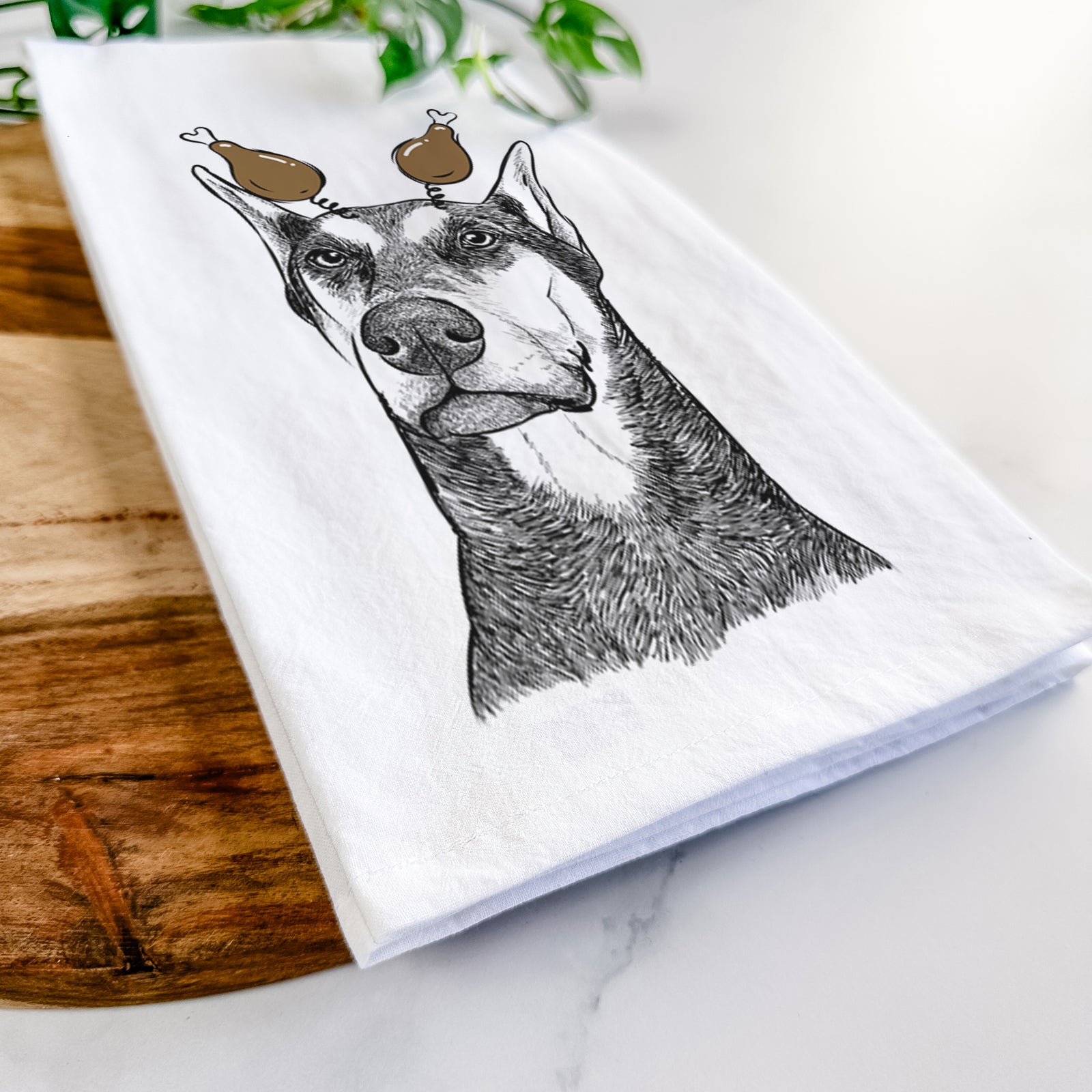 Hand-drawn sketch of Zeus the Doberman Pinscher with a Thanksgiving turkey headpiece on a tea towel