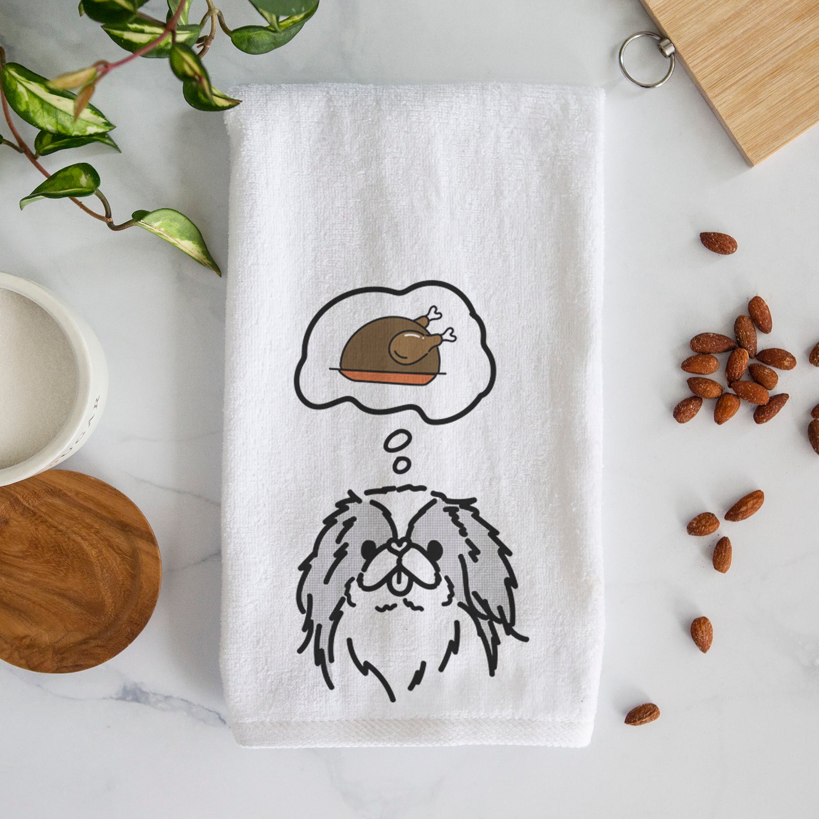 Minimalist line drawing of Macha the Japanese Chin with a little turkey on a decorative hand towel