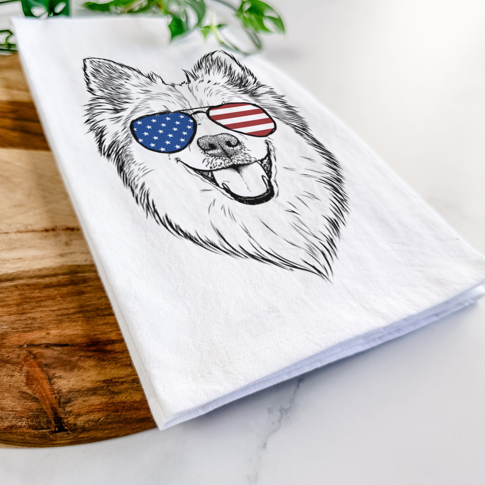 Hand-drawn sketch of Ari the Icelandic Sheepdog wearing American flag sunglasses on a tea towel