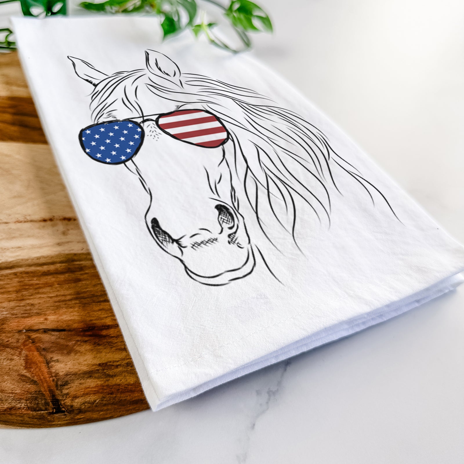 Hand-drawn sketch of Aria the Horse wearing American flag sunglasses on a tea towel