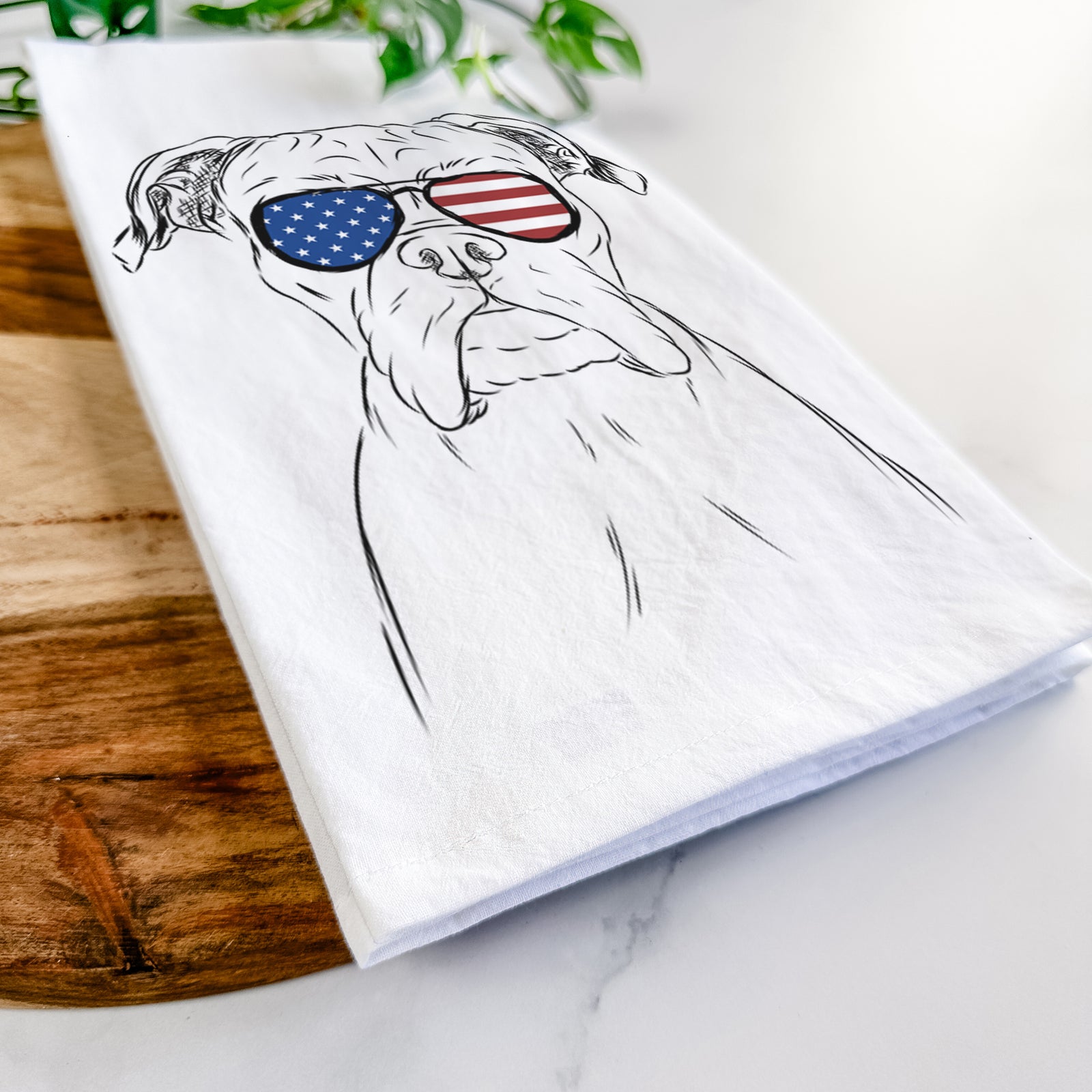 Hand-drawn sketch of Axel the Boxer wearing American flag sunglasses on a tea towel