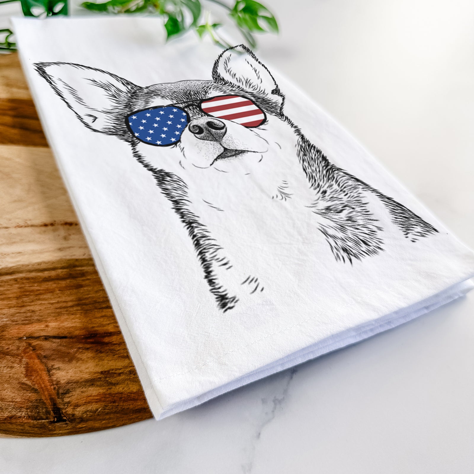 Hand-drawn sketch of Baby the Chihuahua wearing American flag sunglasses on a tea towel