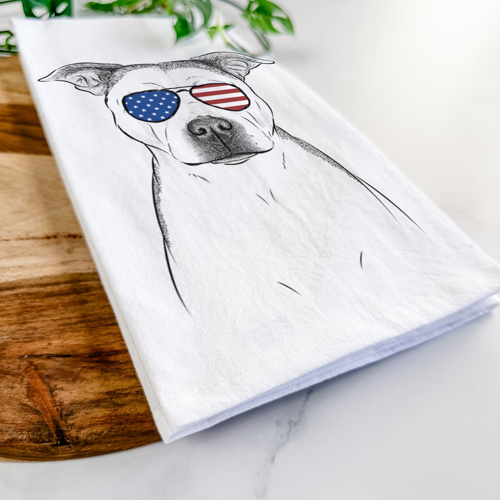 Hand-drawn sketch of Bailey the Pitbull wearing American flag sunglasses on a tea towel