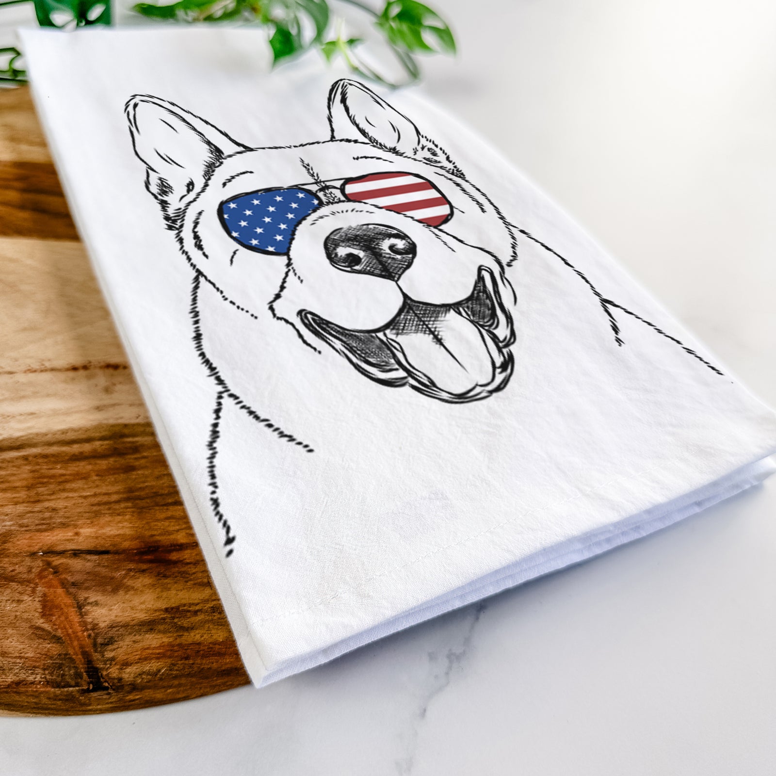 Hand-drawn sketch of Baku the Akita wearing American flag sunglasses on a tea towel