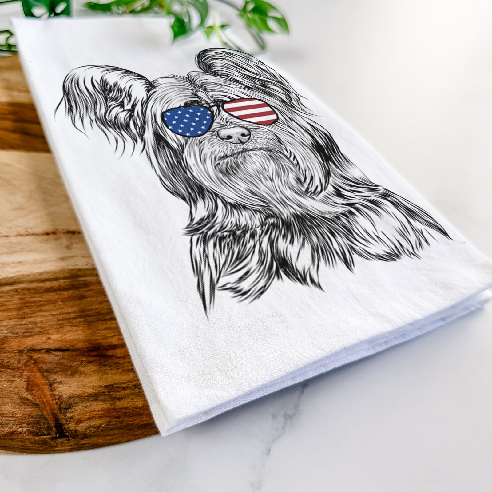 Hand-drawn sketch of Bandit the Skye Terrier wearing American flag sunglasses on a tea towel