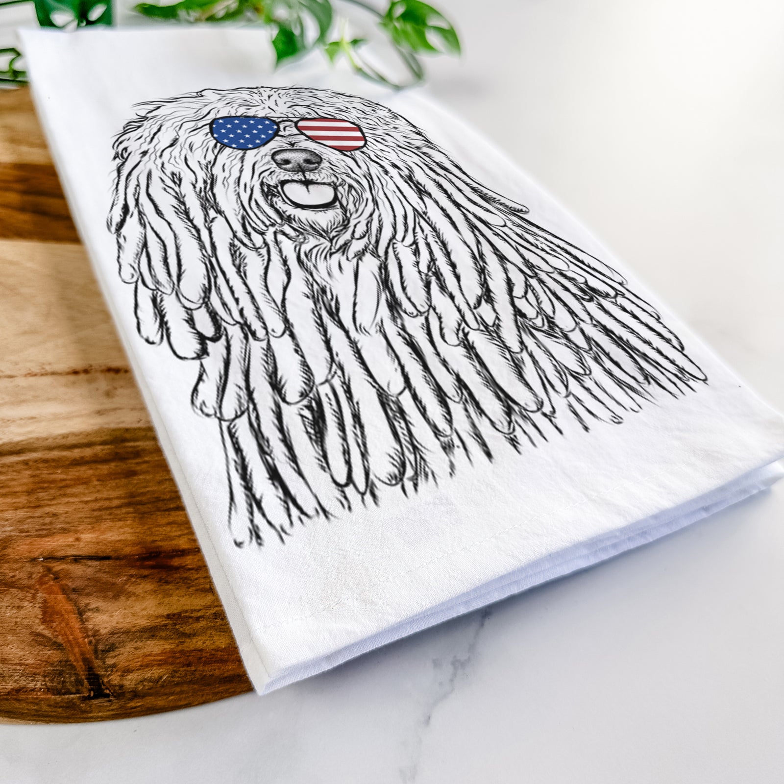 Hand-drawn sketch of Barry the Komondor wearing American flag sunglasses on a tea towel