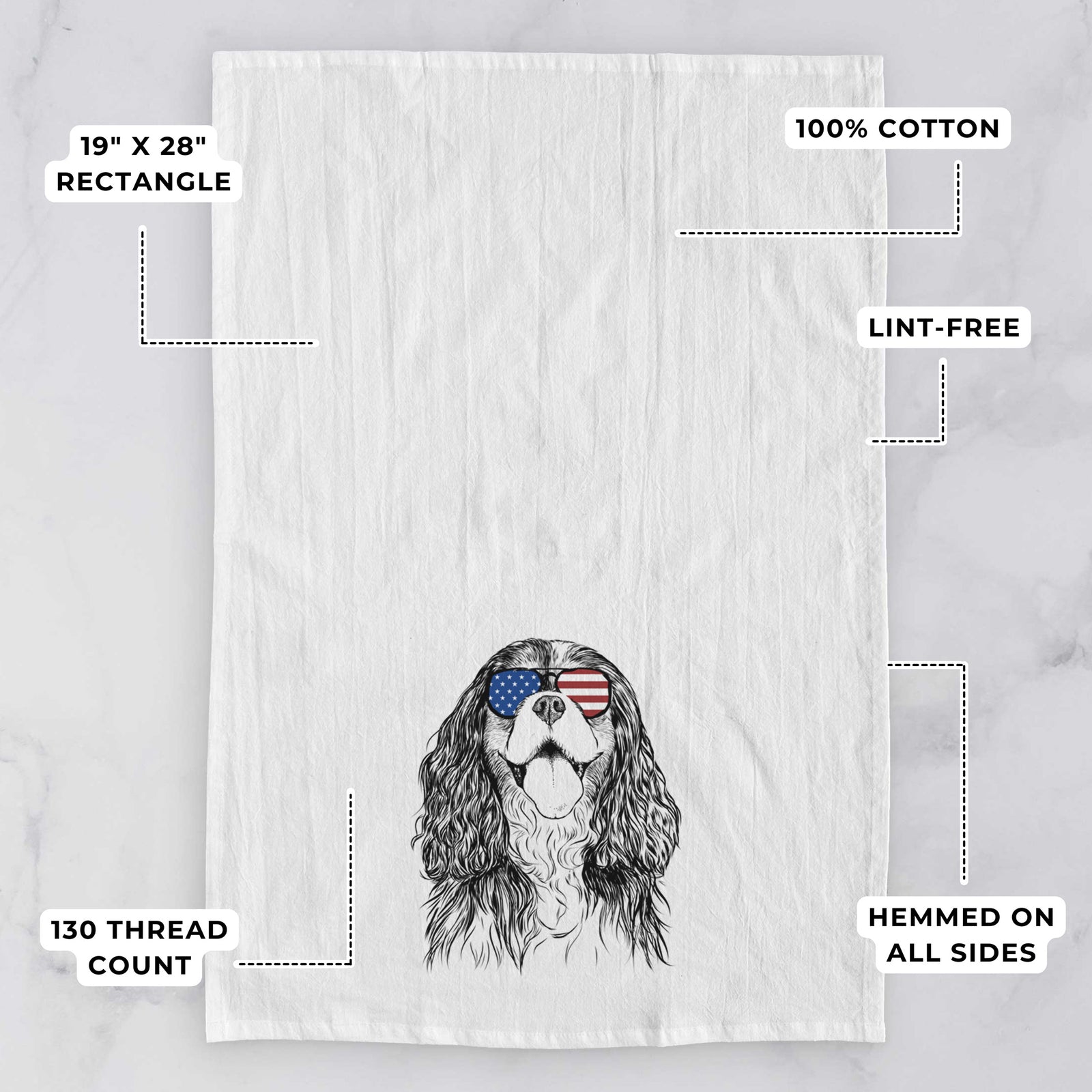 Hand-drawn sketch of Brandy the Cavalier King Charles Spaniel wearing American flag sunglasses on a tea towel, with feature callouts: 19 x 28 inch rectangle, 100% cotton, lint-free, 120 thread count, hemmed on all sides