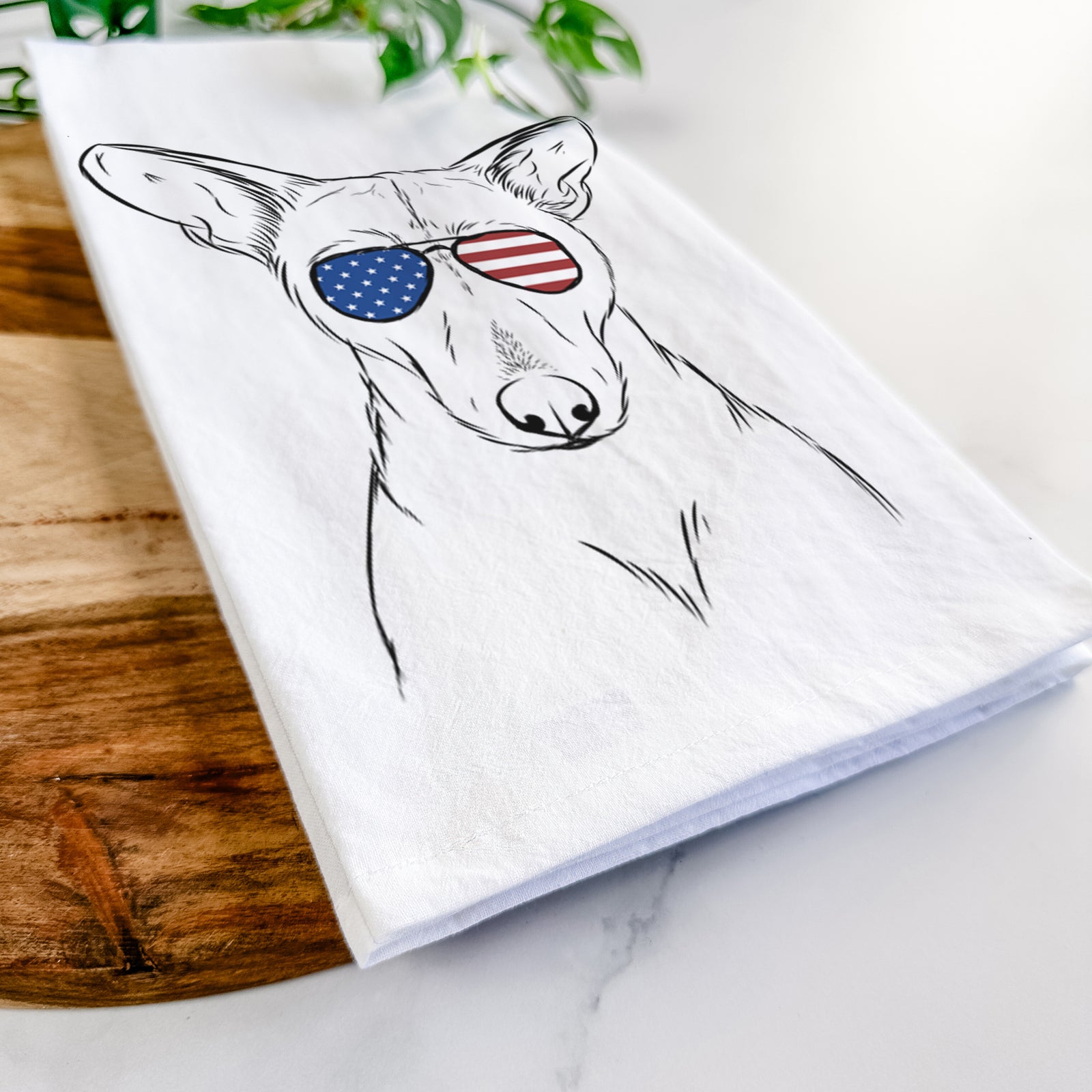 Hand-drawn sketch of Buff the Dorgi wearing American flag sunglasses on a tea towel