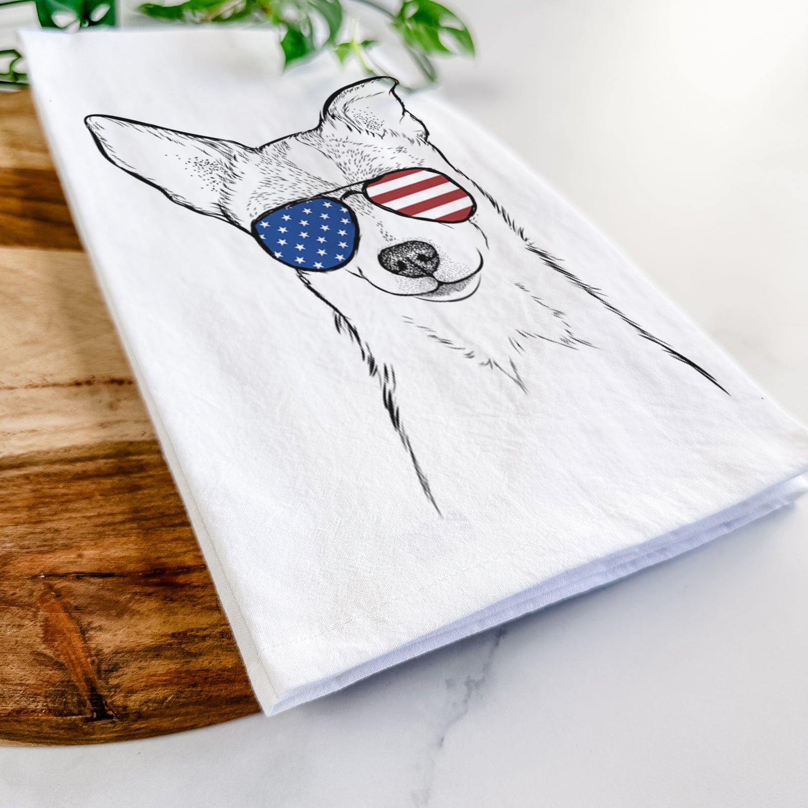 Hand-drawn sketch of Buggy the Chihuahua wearing American flag sunglasses on a tea towel