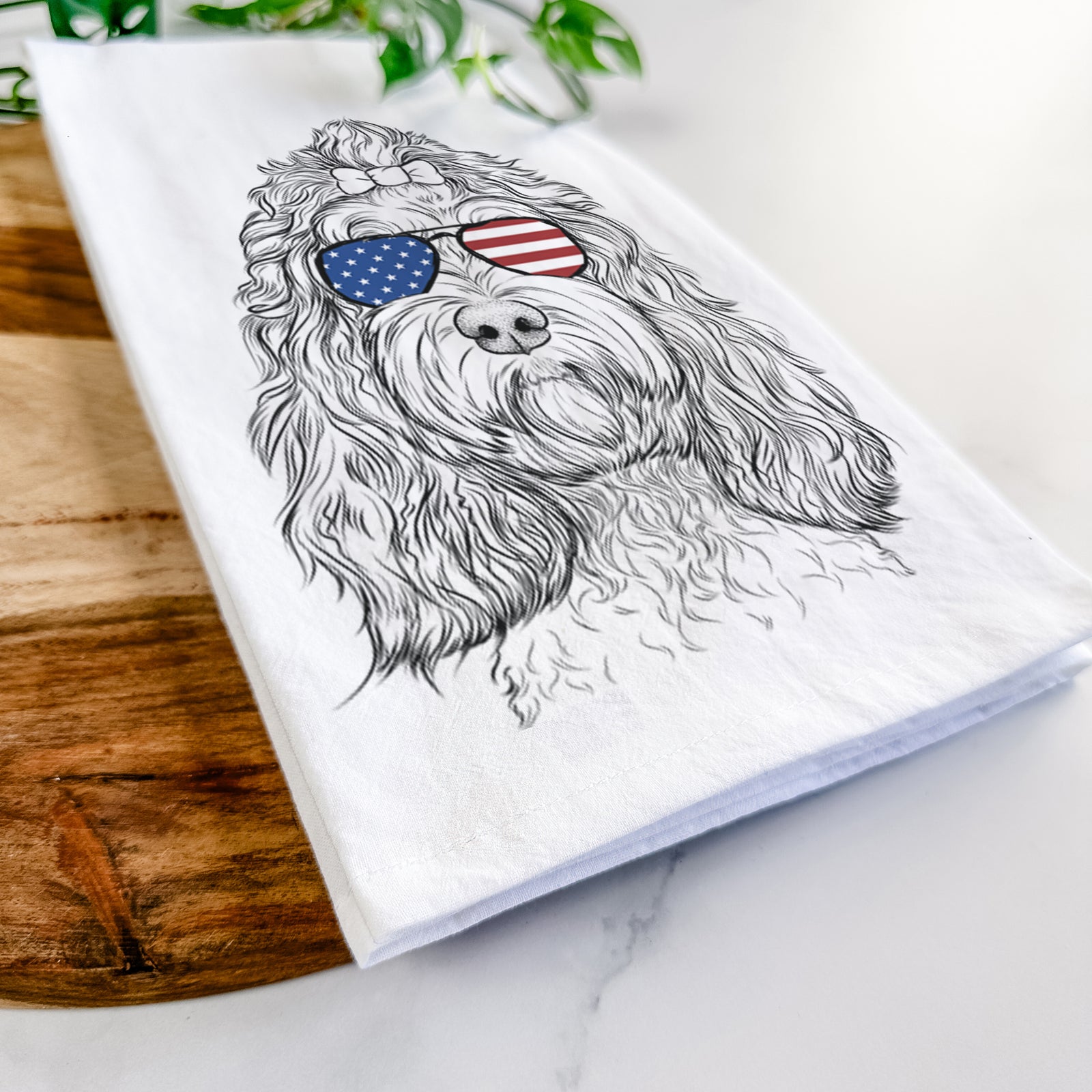 Hand-drawn sketch of Chloe the Cockapoo wearing American flag sunglasses on a tea towel