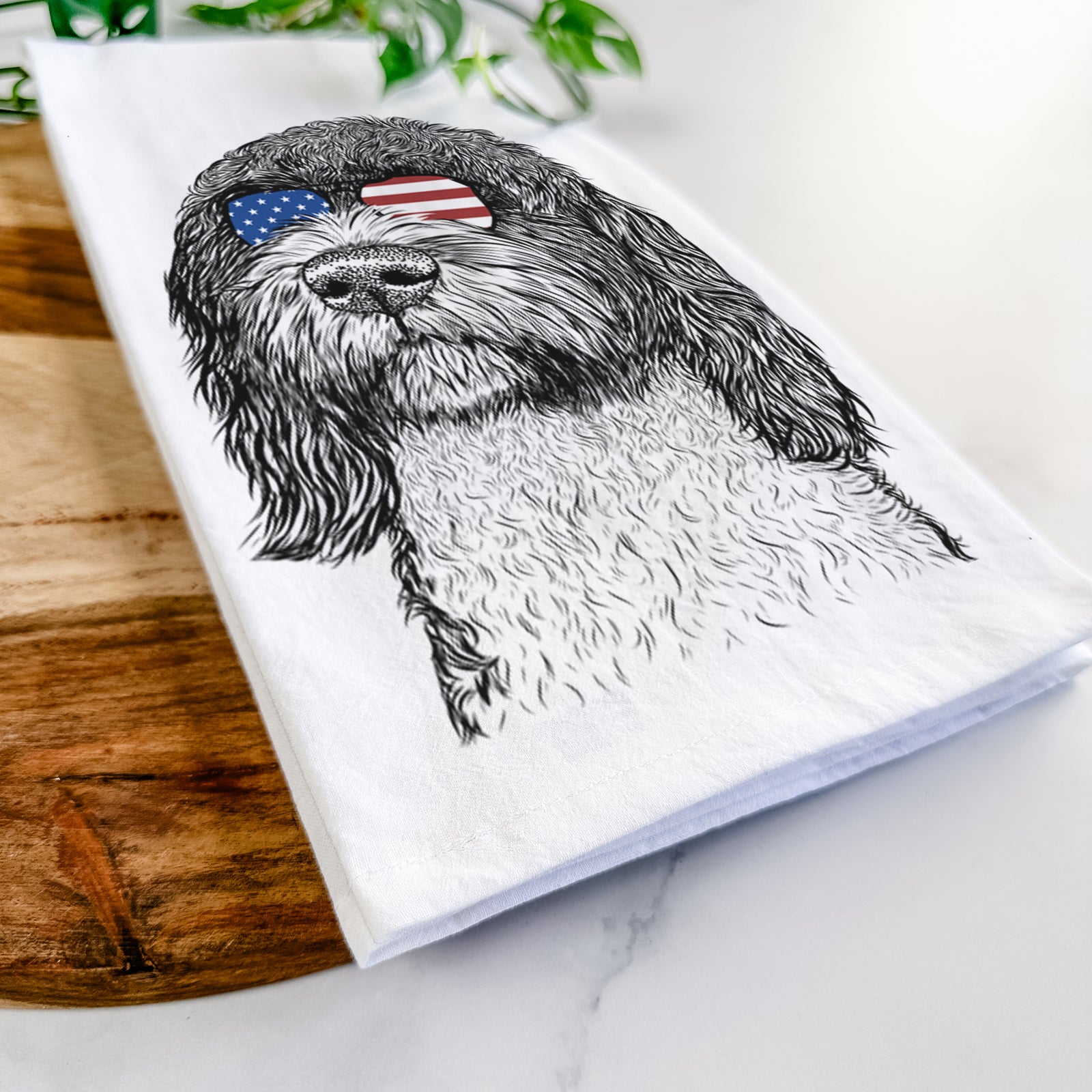 Hand-drawn sketch of Chris the Portuguese Water Dog wearing American flag sunglasses on a tea towel