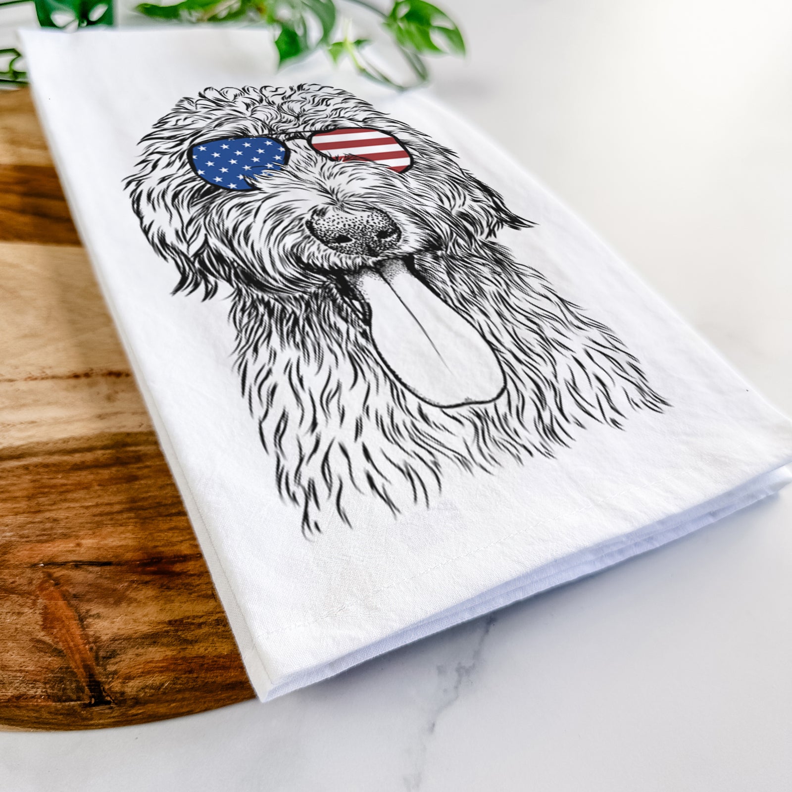 Hand-drawn sketch of CiCi Paulk the Aussiedoodle wearing American flag sunglasses on a tea towel