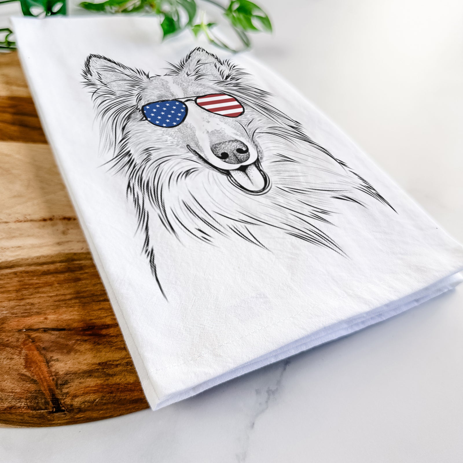 Hand-drawn sketch of Conrad the Rough Collie wearing American flag sunglasses on a tea towel