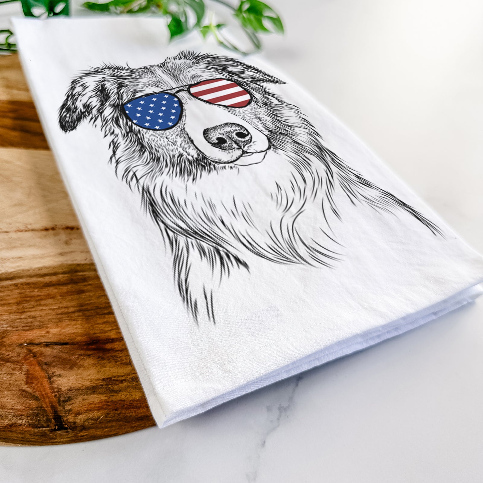 Hand-drawn sketch of Cynder the English Shepherd wearing American flag sunglasses on a tea towel