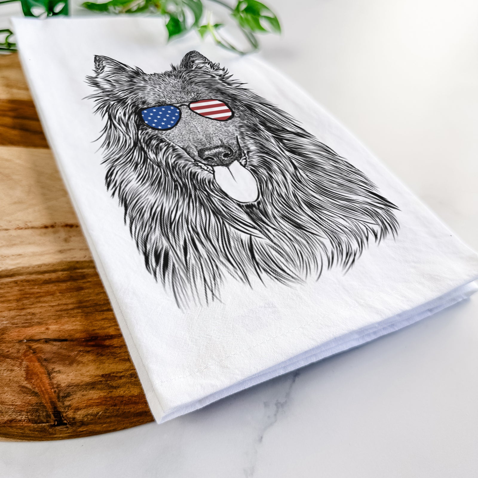 Hand-drawn sketch of Daan the Belgian Shepherd wearing American flag sunglasses on a tea towel