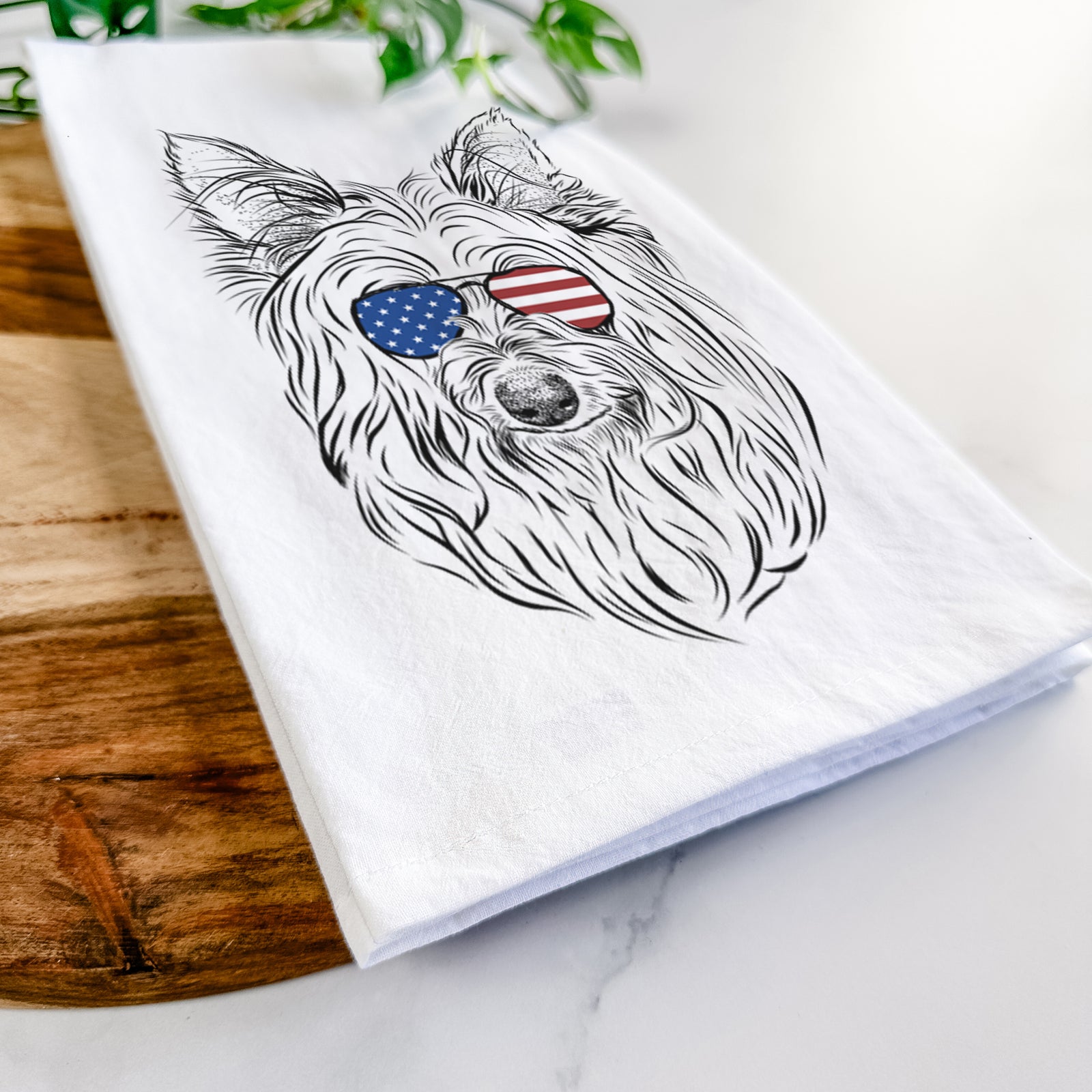 Hand-drawn sketch of Daisy May the Silky Terrier wearing American flag sunglasses on a tea towel