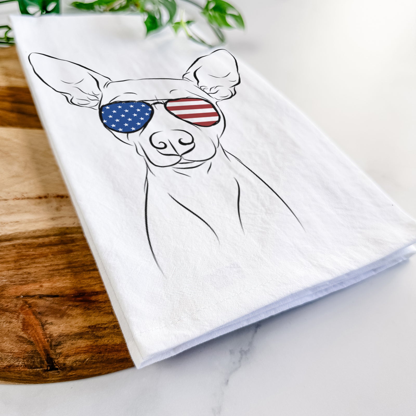 Hand-drawn sketch of Desi the American Hairless Terrier wearing American flag sunglasses on a tea towel