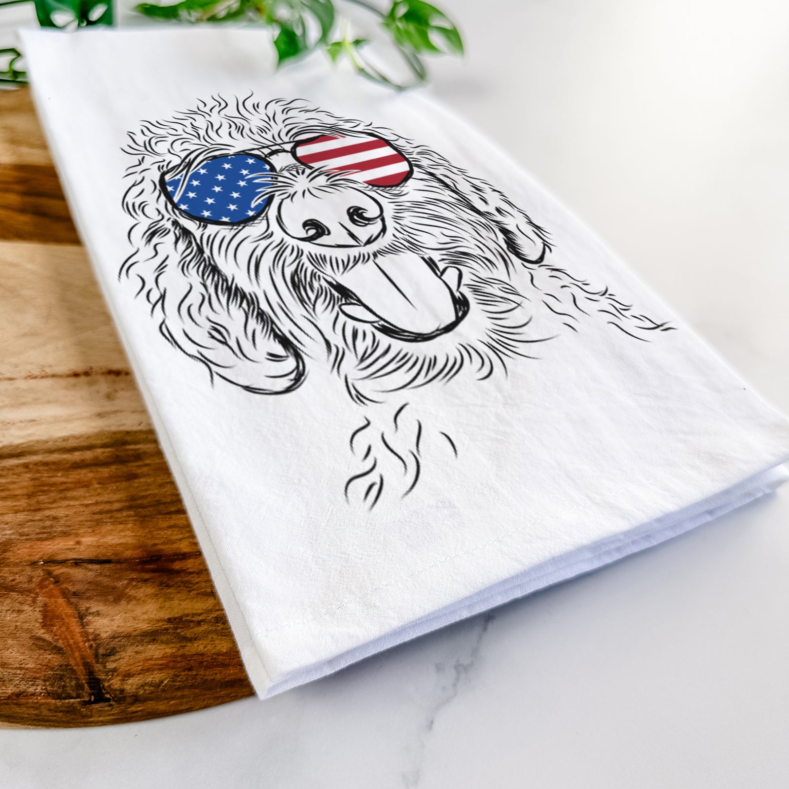 Hand-drawn sketch of Dixie the Doodle wearing American flag sunglasses on a tea towel