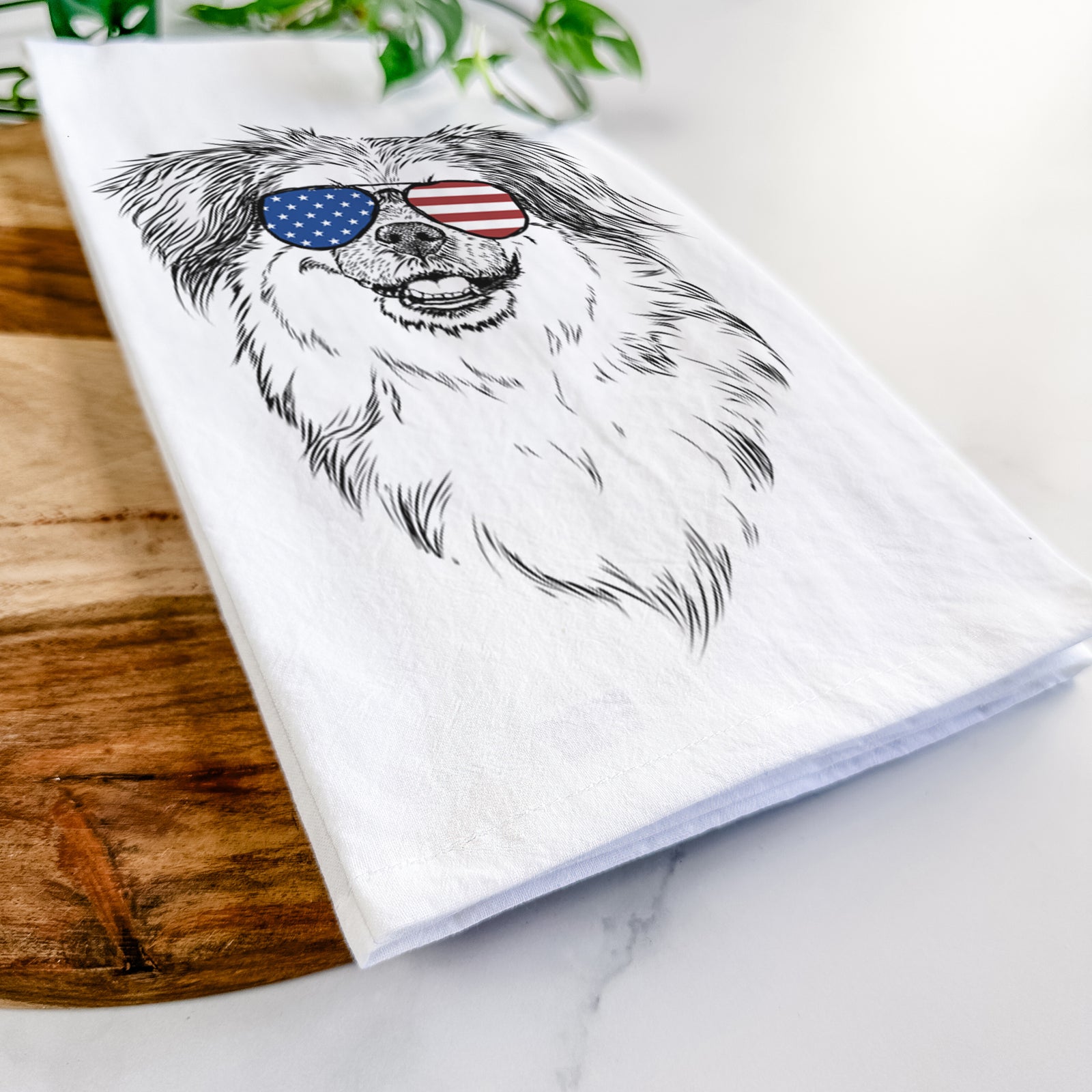 Hand-drawn sketch of Ed the Tibetan Spaniel wearing American flag sunglasses on a tea towel