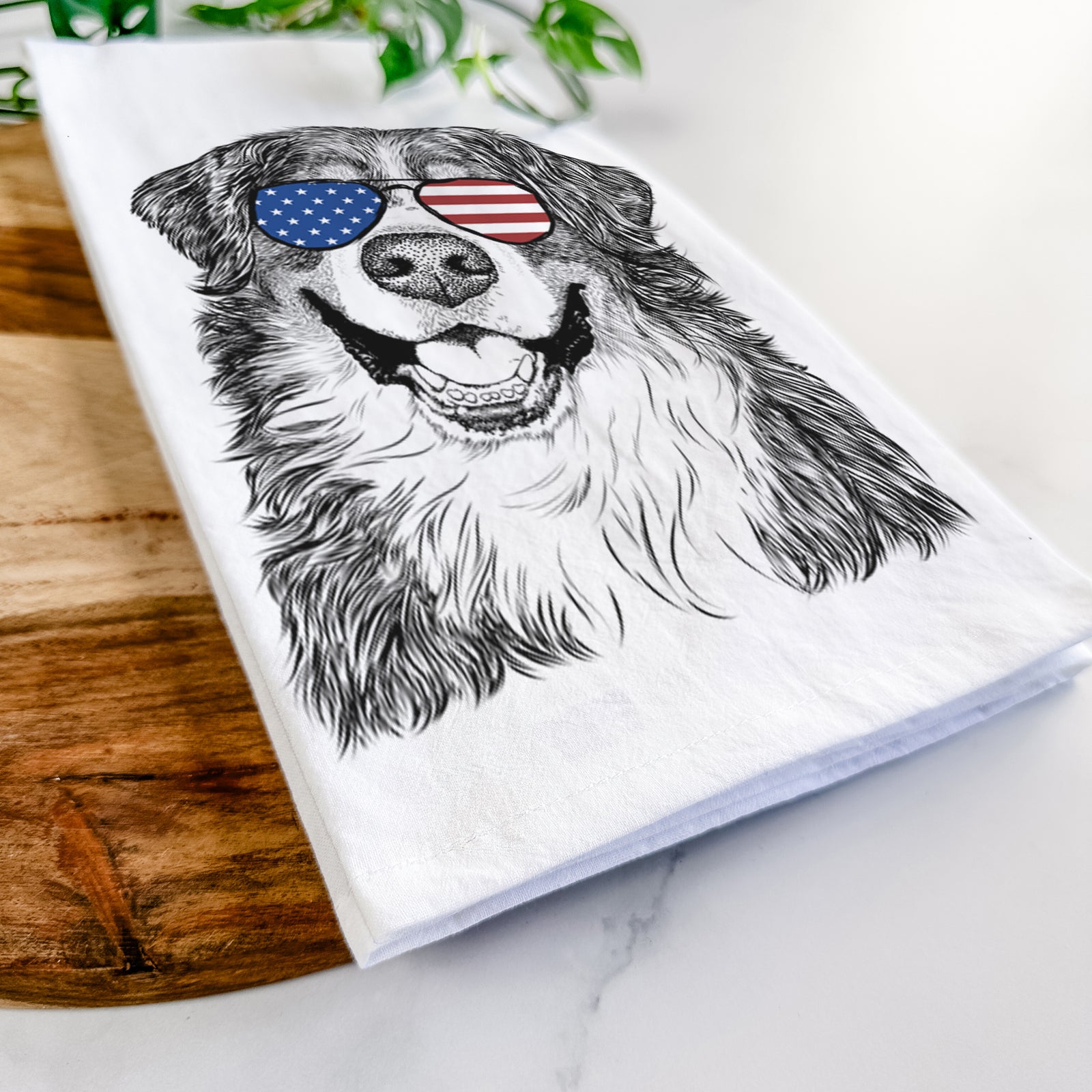 Hand-drawn sketch of Eiger the Bernese Mountain Dog wearing American flag sunglasses on a tea towel