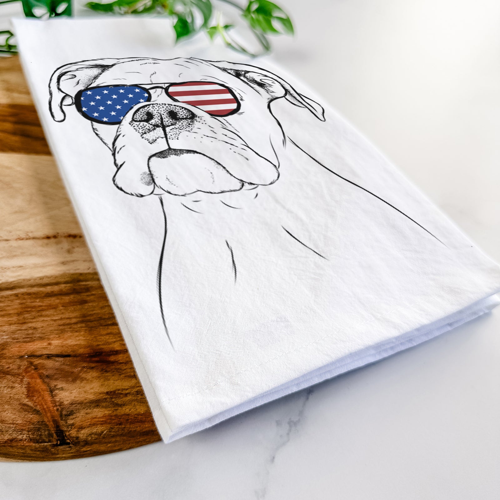 Hand-drawn sketch of Ellie the Boxer wearing American flag sunglasses on a tea towel