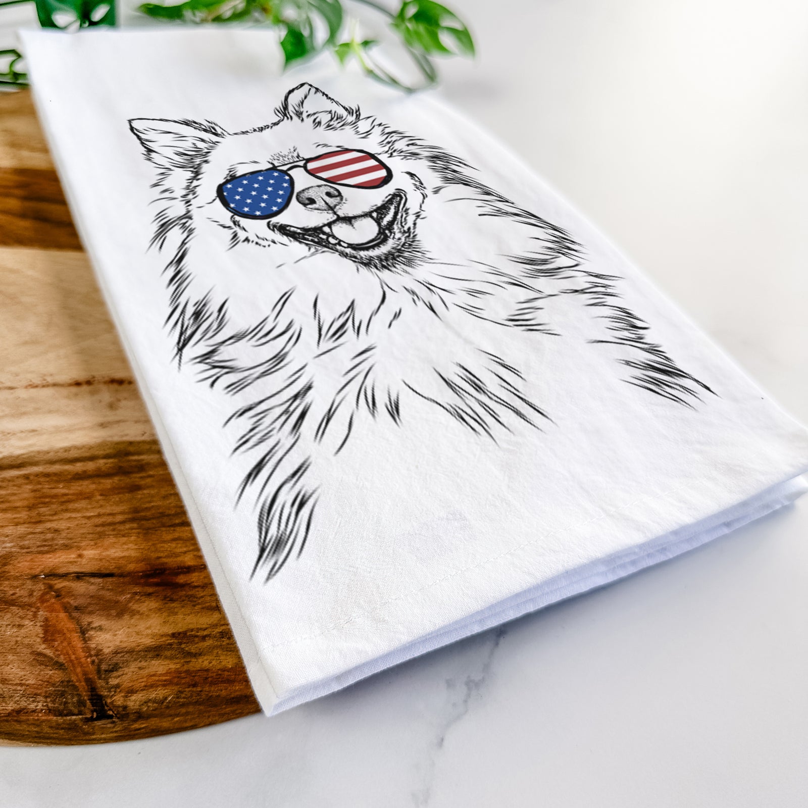Hand-drawn sketch of Fibi the Spitz wearing American flag sunglasses on a tea towel