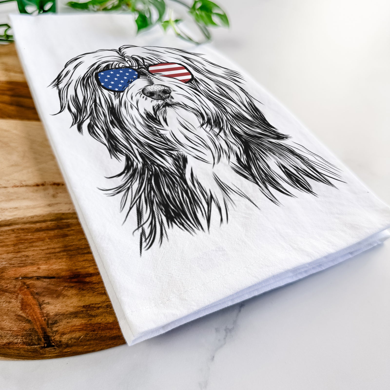 Hand-drawn sketch of Fiji the Polish Lowland Sheepdog wearing American flag sunglasses on a tea towel
