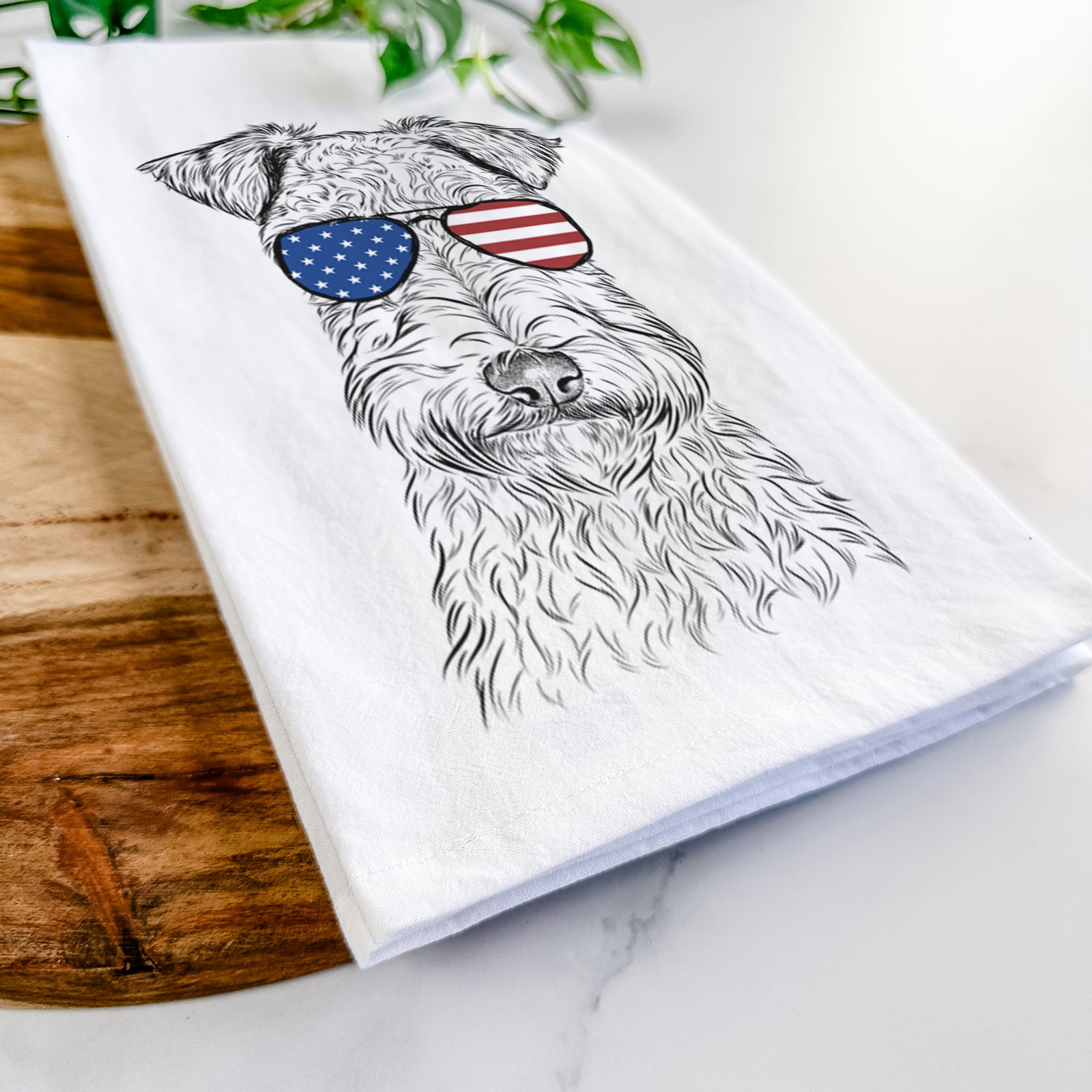 Hand-drawn sketch of Frida the Lakeland Terrier wearing American flag sunglasses on a tea towel