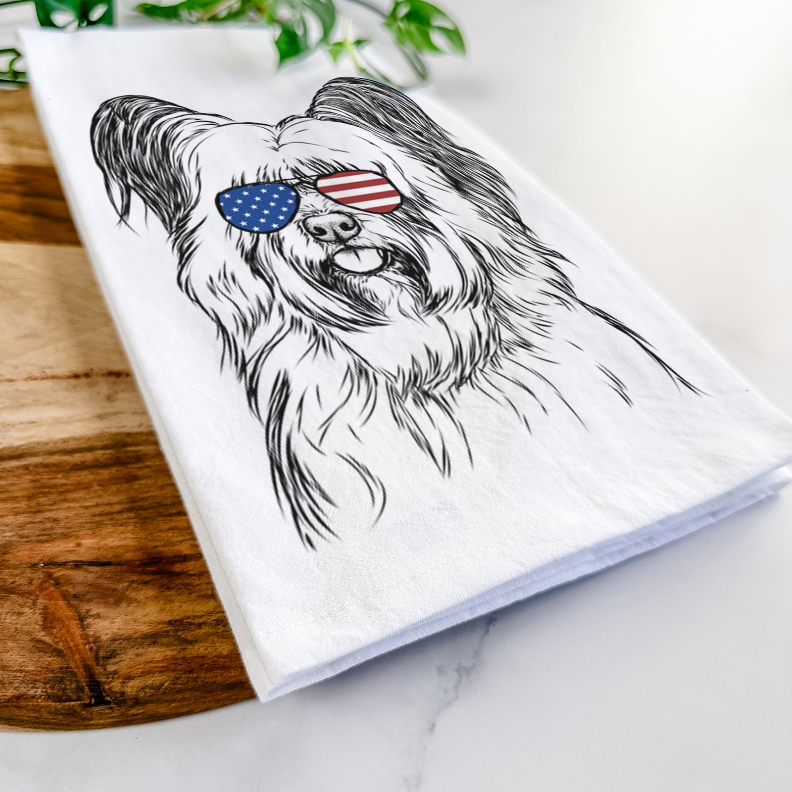 Hand-drawn sketch of Gideon the Skye Terrier wearing American flag sunglasses on a tea towel