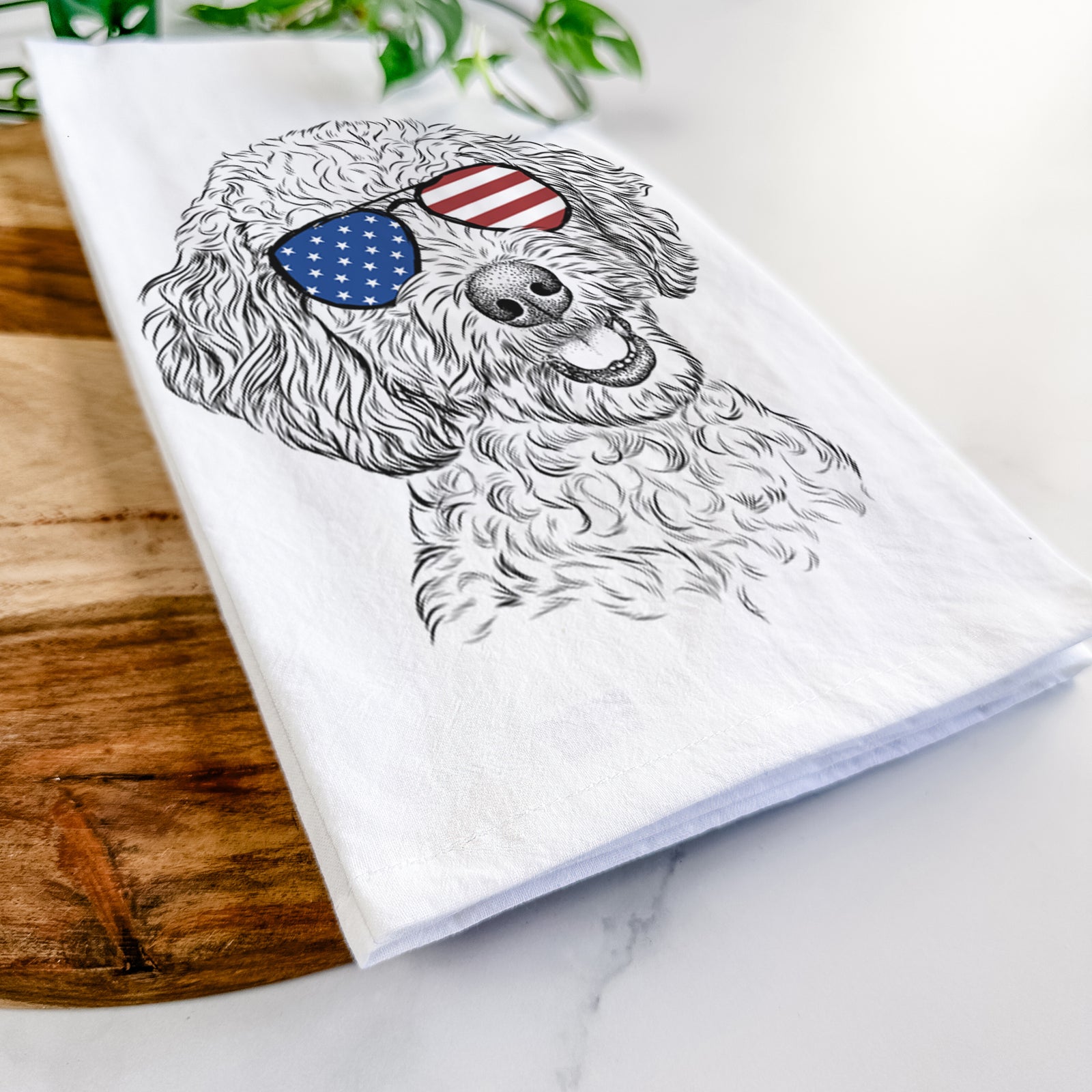 Hand-drawn sketch of Gizmo the Goldendoodle wearing American flag sunglasses on a tea towel