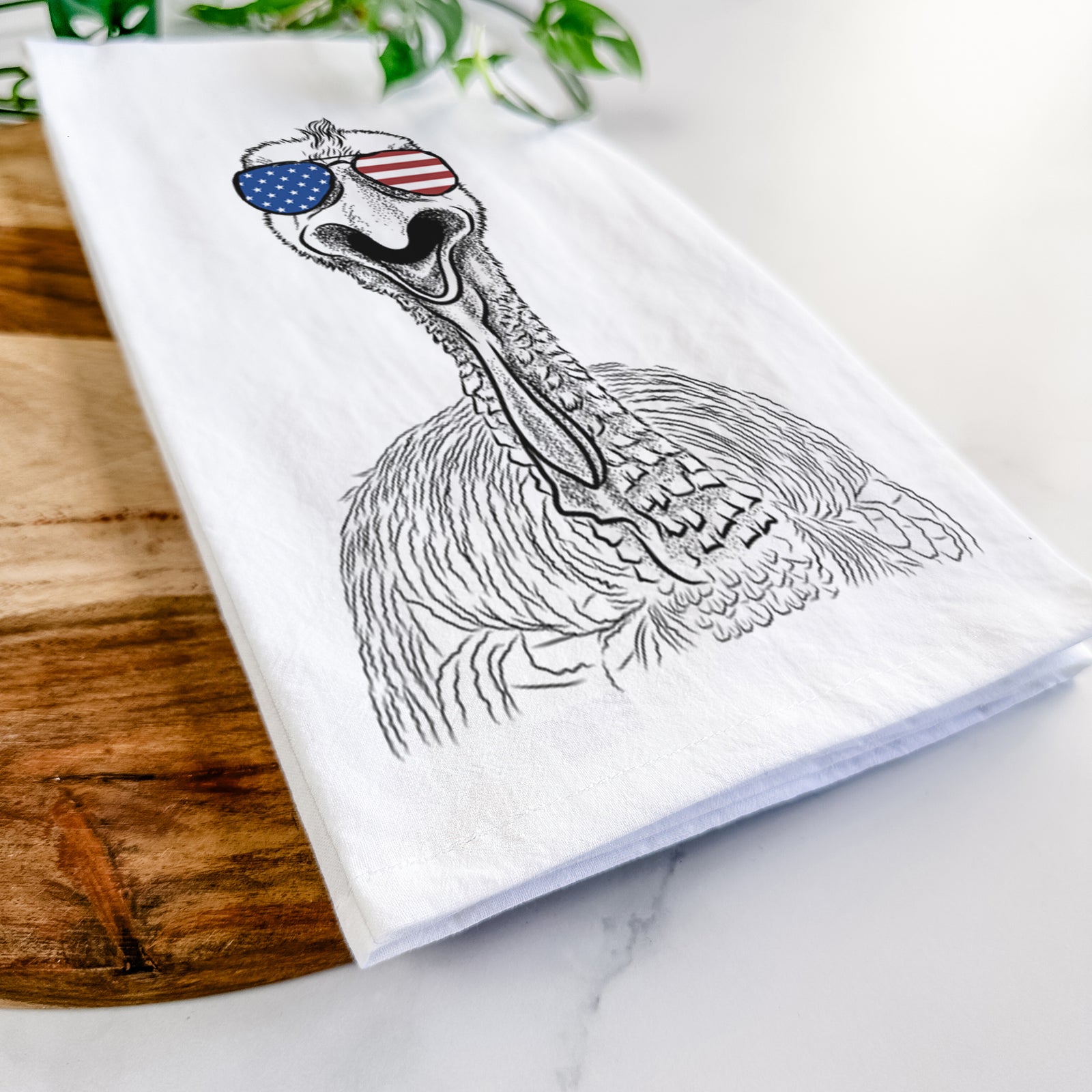 Hand-drawn sketch of Gobble the Turkey wearing American flag sunglasses on a tea towel