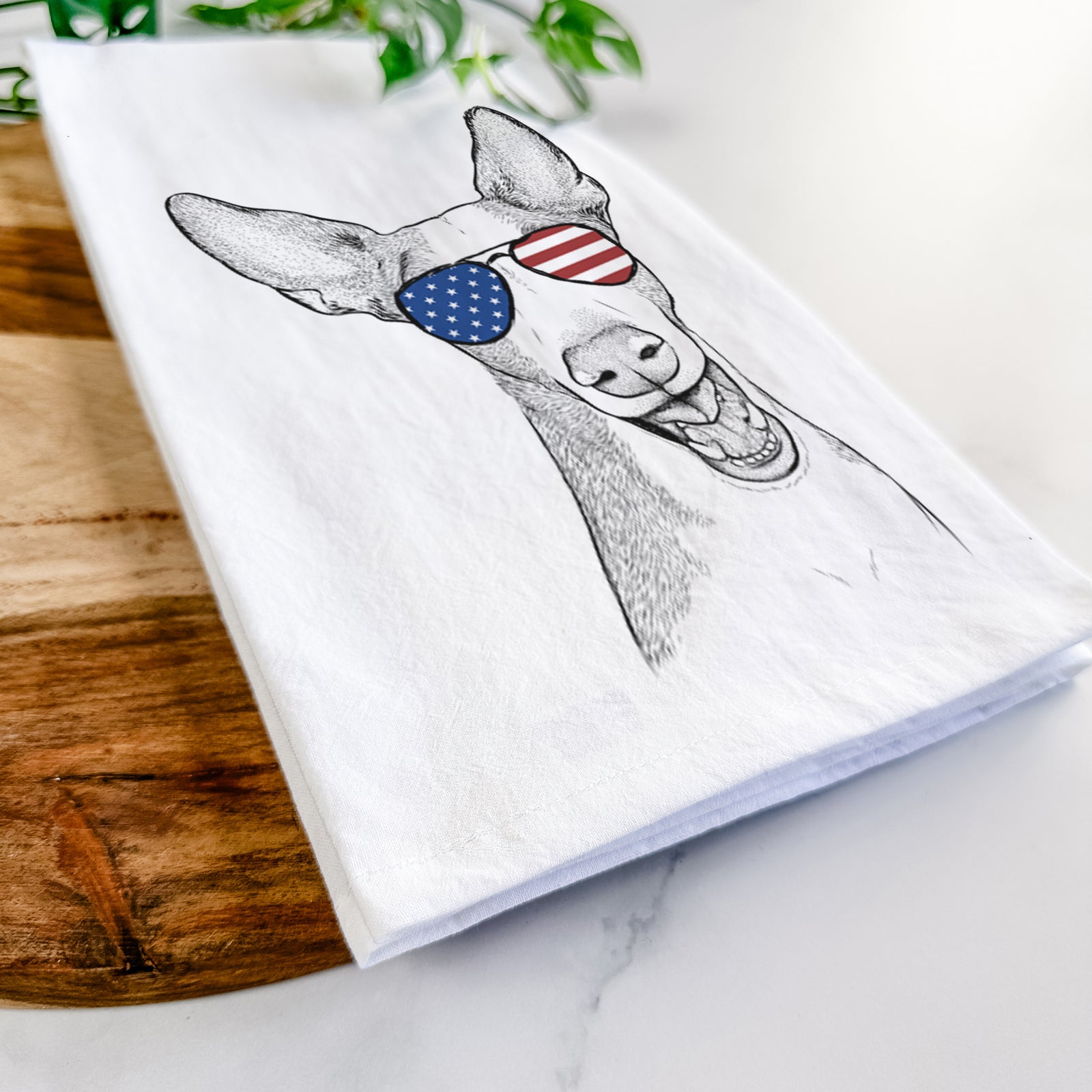 Hand-drawn sketch of Havok the Ibizan Hound wearing American flag sunglasses on a tea towel