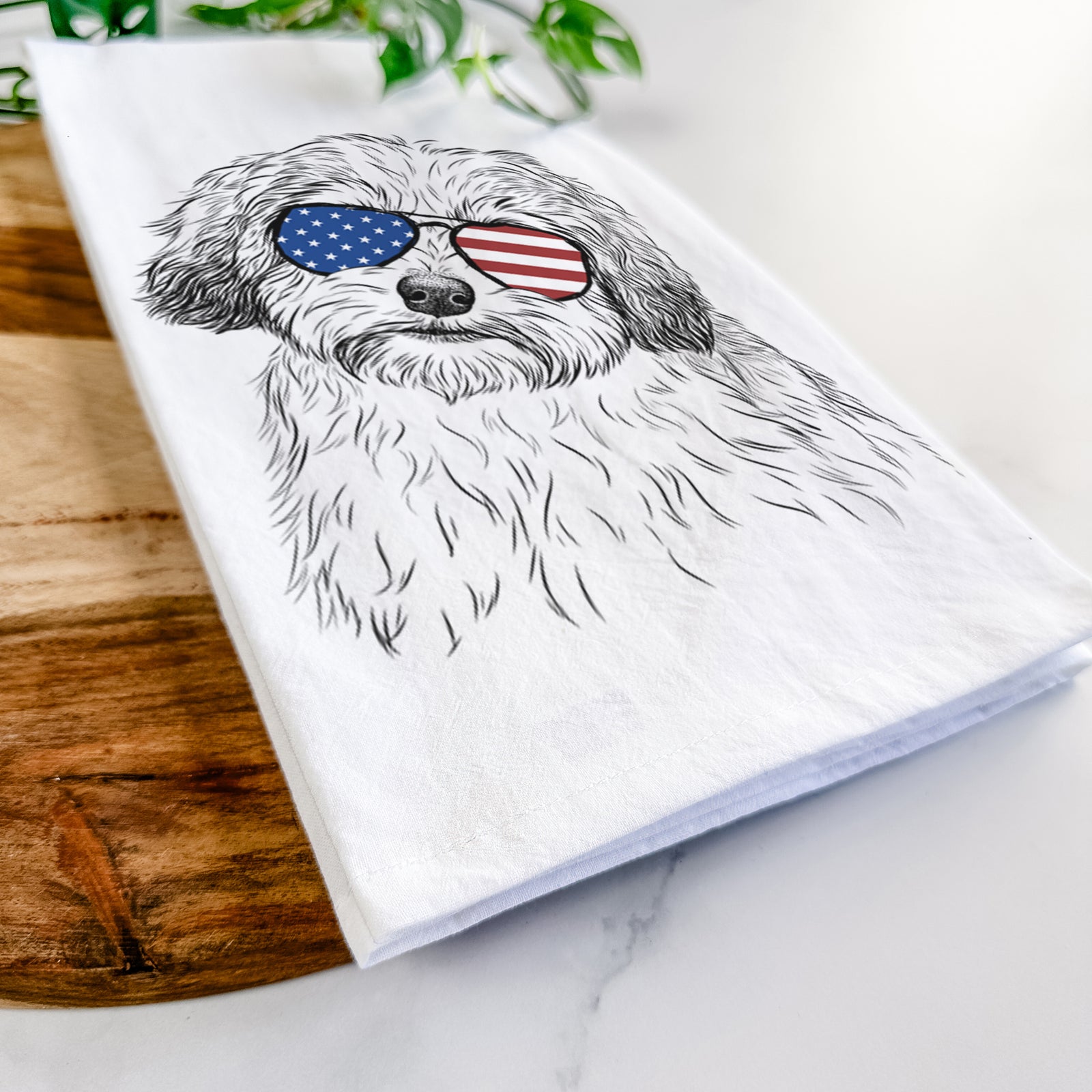 Hand-drawn sketch of Henry the Havanese wearing American flag sunglasses on a tea towel
