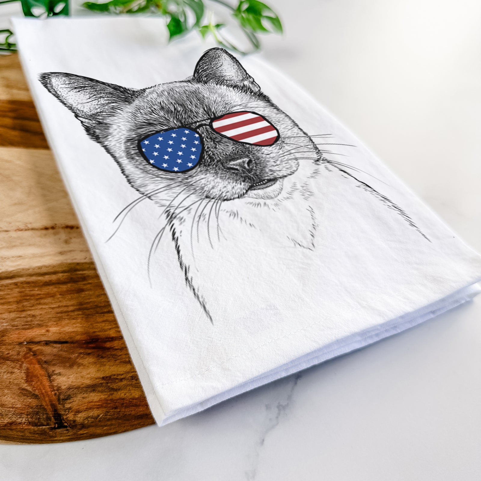 Hand-drawn sketch of Hoggle the Siamese Cat wearing American flag sunglasses on a tea towel