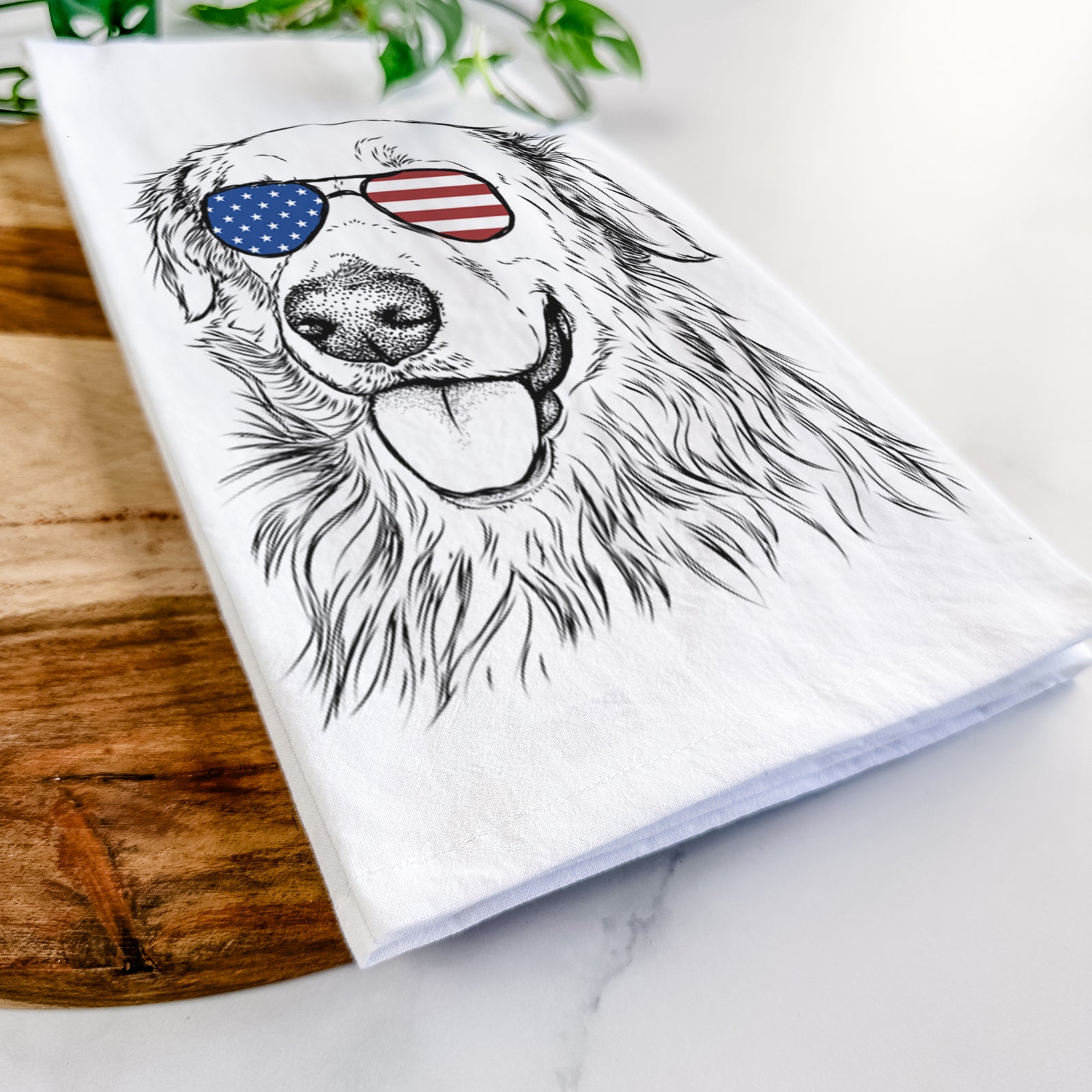 Hand-drawn sketch of Hopper the Golden Retriever wearing American flag sunglasses on a tea towel