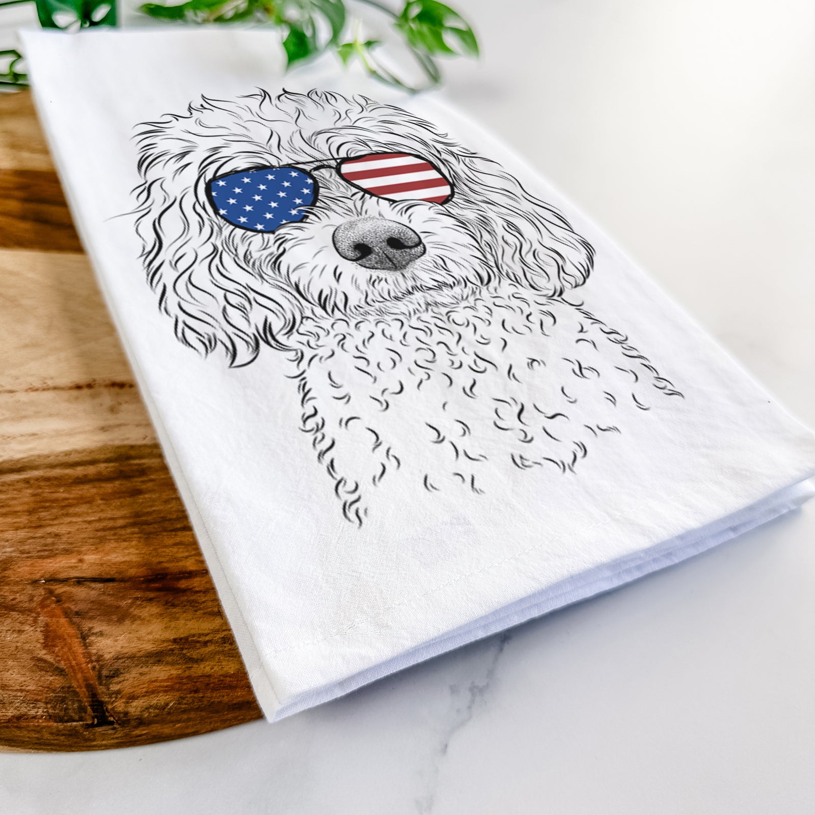 Hand-drawn sketch of Izzie the Cavachon wearing American flag sunglasses on a tea towel