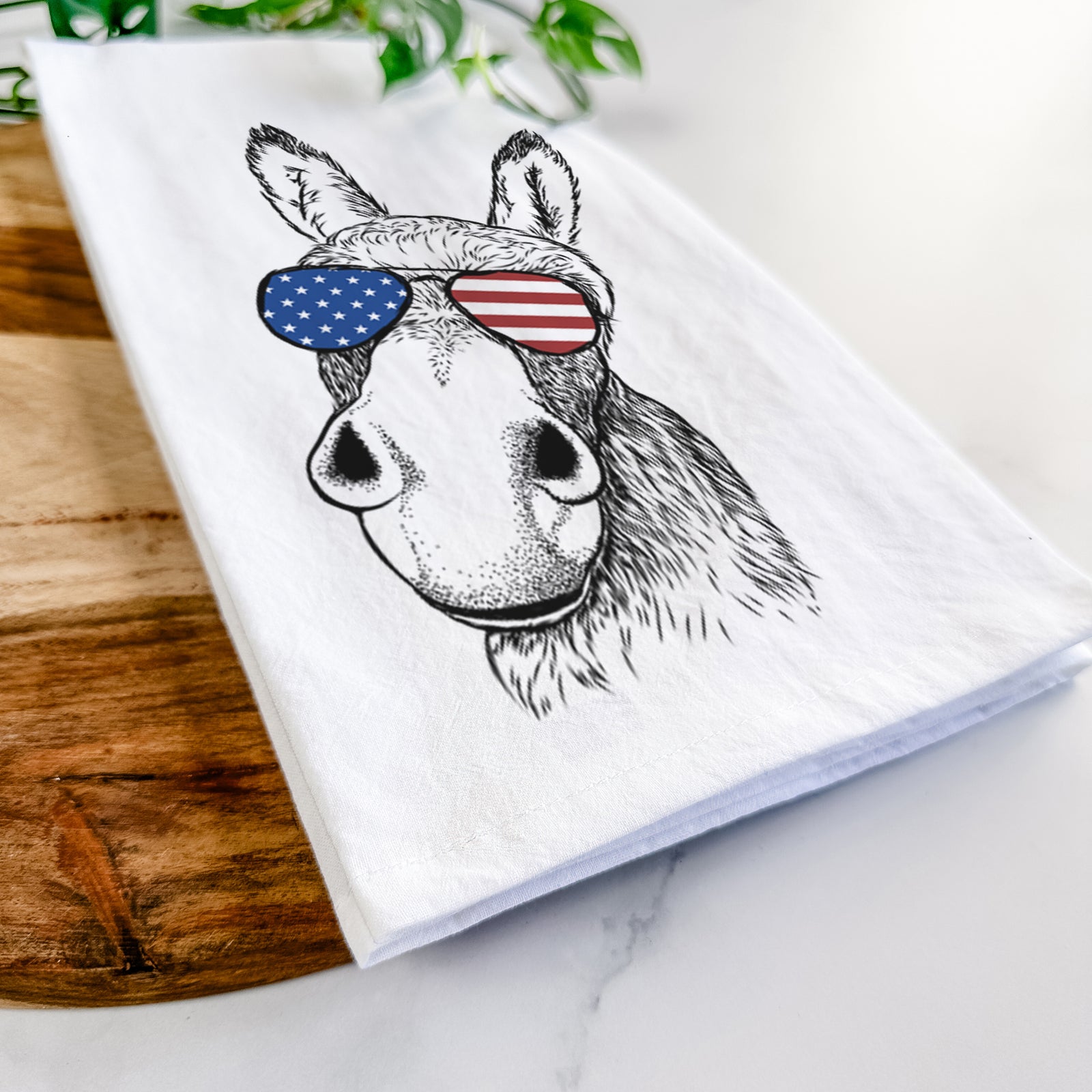Hand-drawn sketch of Jenny the Donkey wearing American flag sunglasses on a tea towel