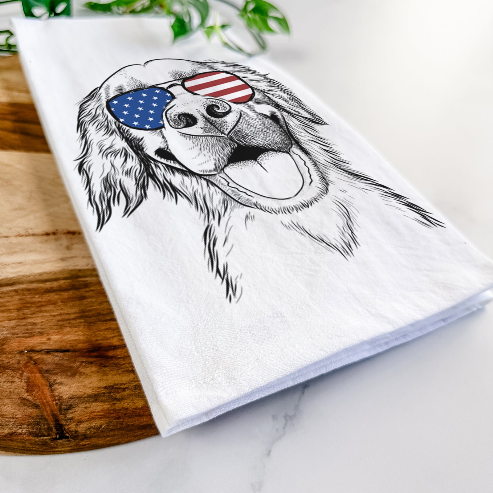 Hand-drawn sketch of Jordy the Golden Retriever wearing American flag sunglasses on a tea towel