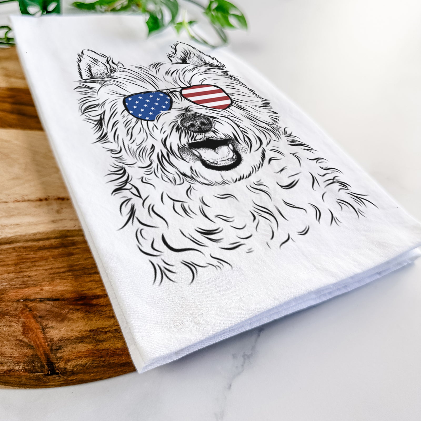 Hand-drawn sketch of Kami the West Highland Terrier wearing American flag sunglasses on a tea towel