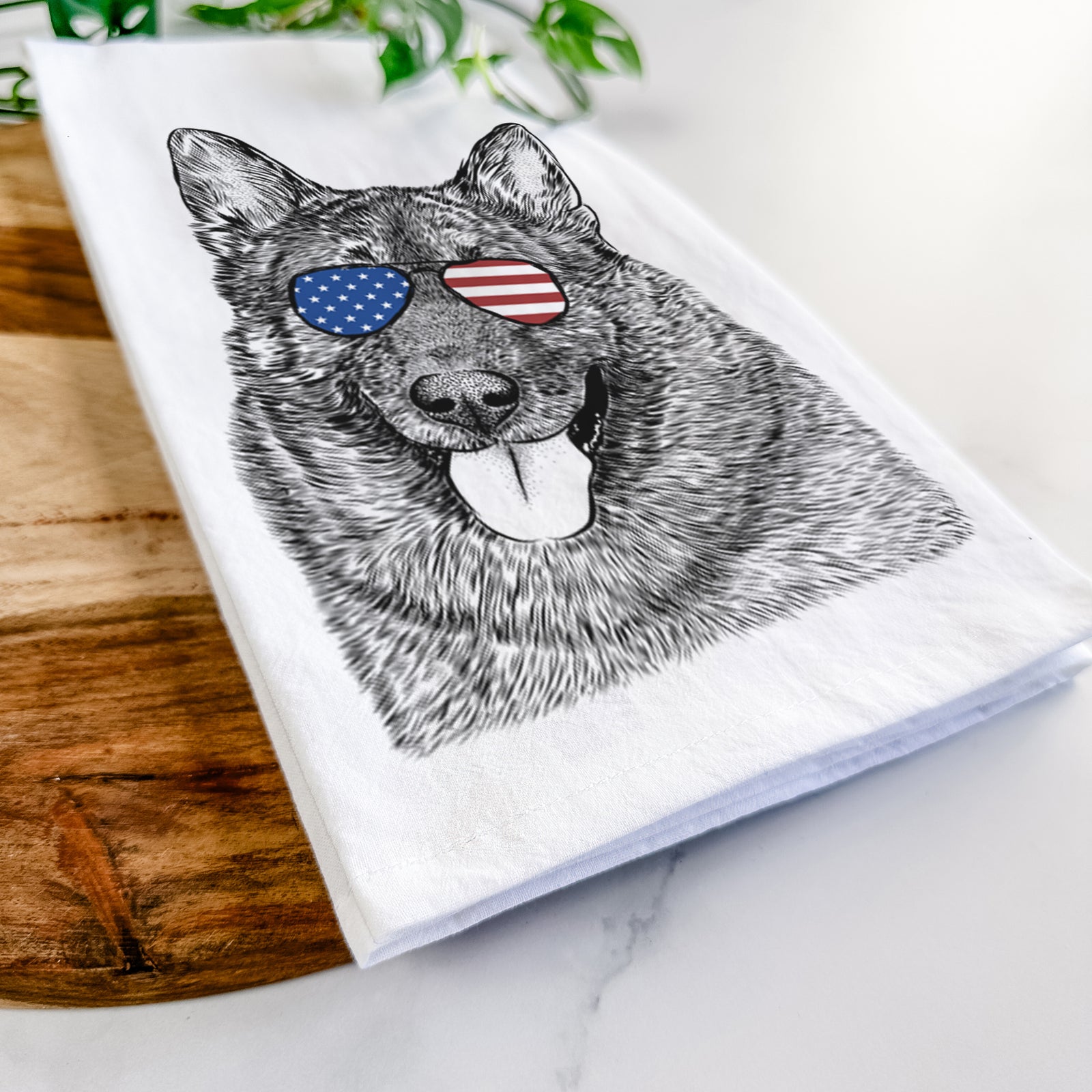 Hand-drawn sketch of Kasia the Norwegian Elkhound wearing American flag sunglasses on a tea towel