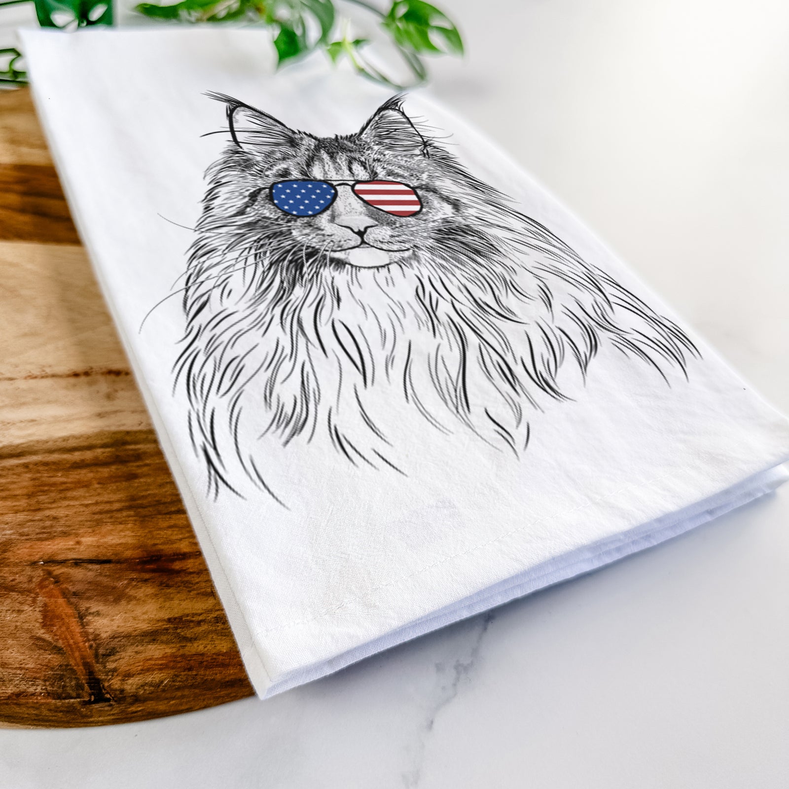 Hand-drawn sketch of Kiki the Maine Coon Cat wearing American flag sunglasses on a tea towel
