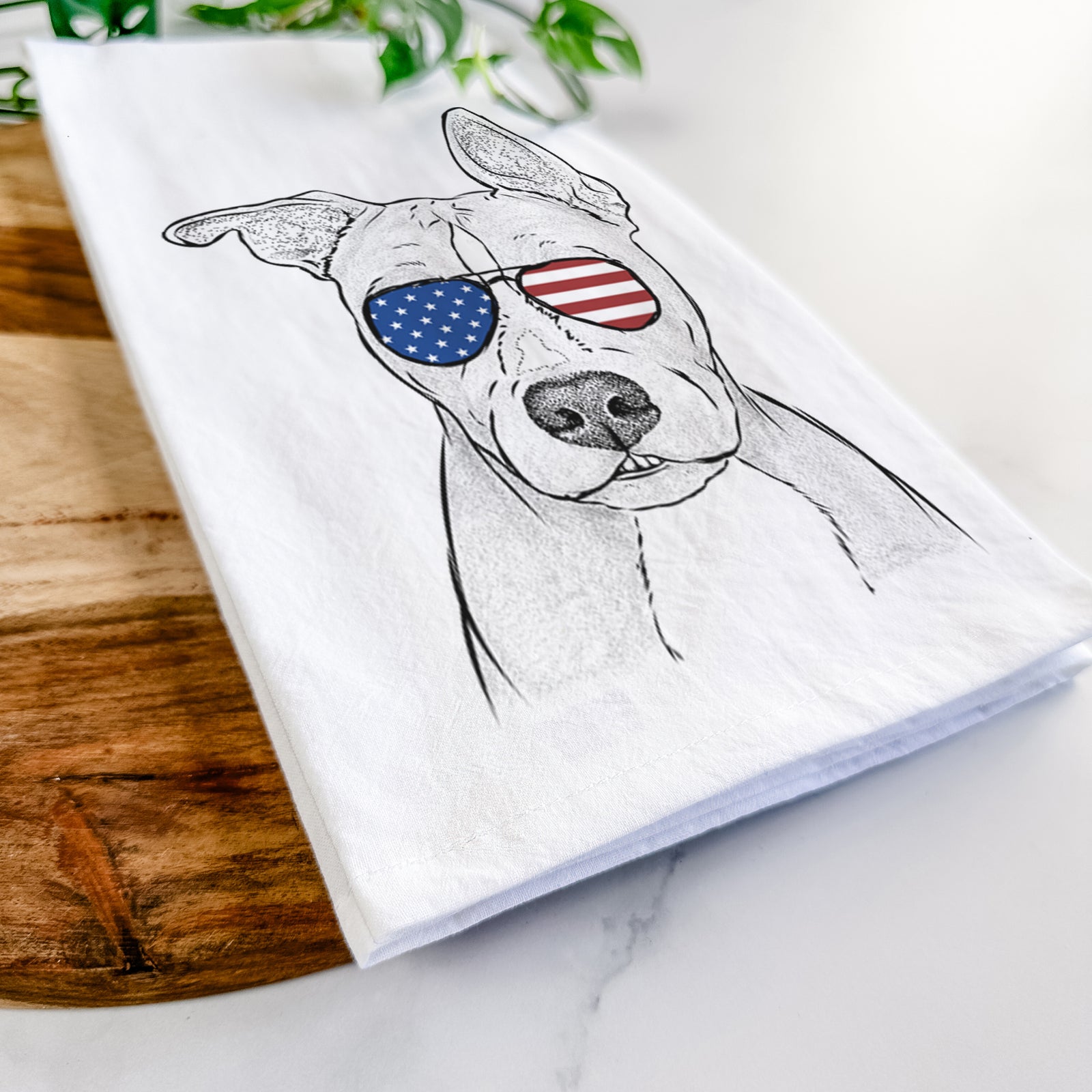 Hand-drawn sketch of Kisses the Pitbull wearing American flag sunglasses on a tea towel