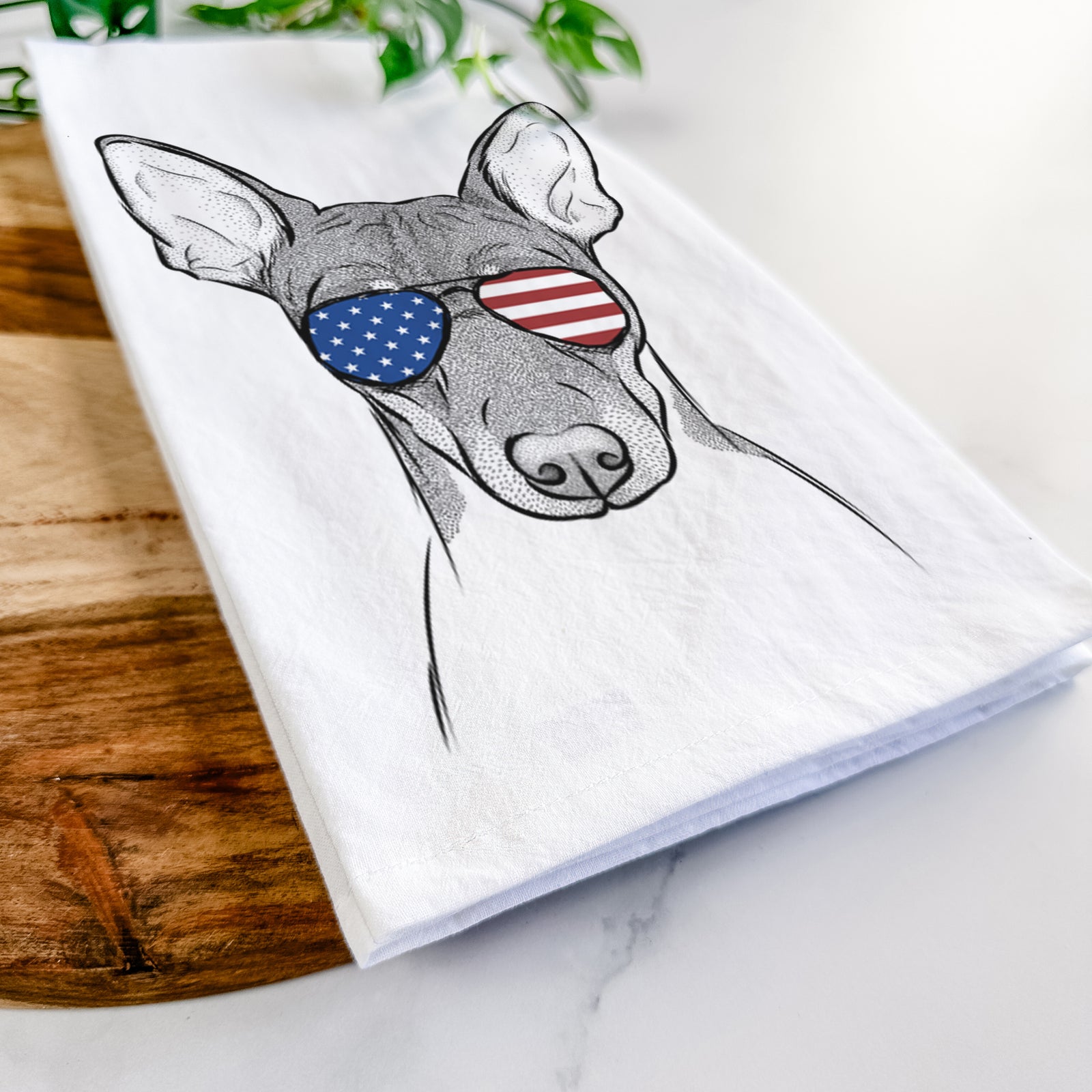Hand-drawn sketch of Knox the Rat Terrier wearing American flag sunglasses on a tea towel