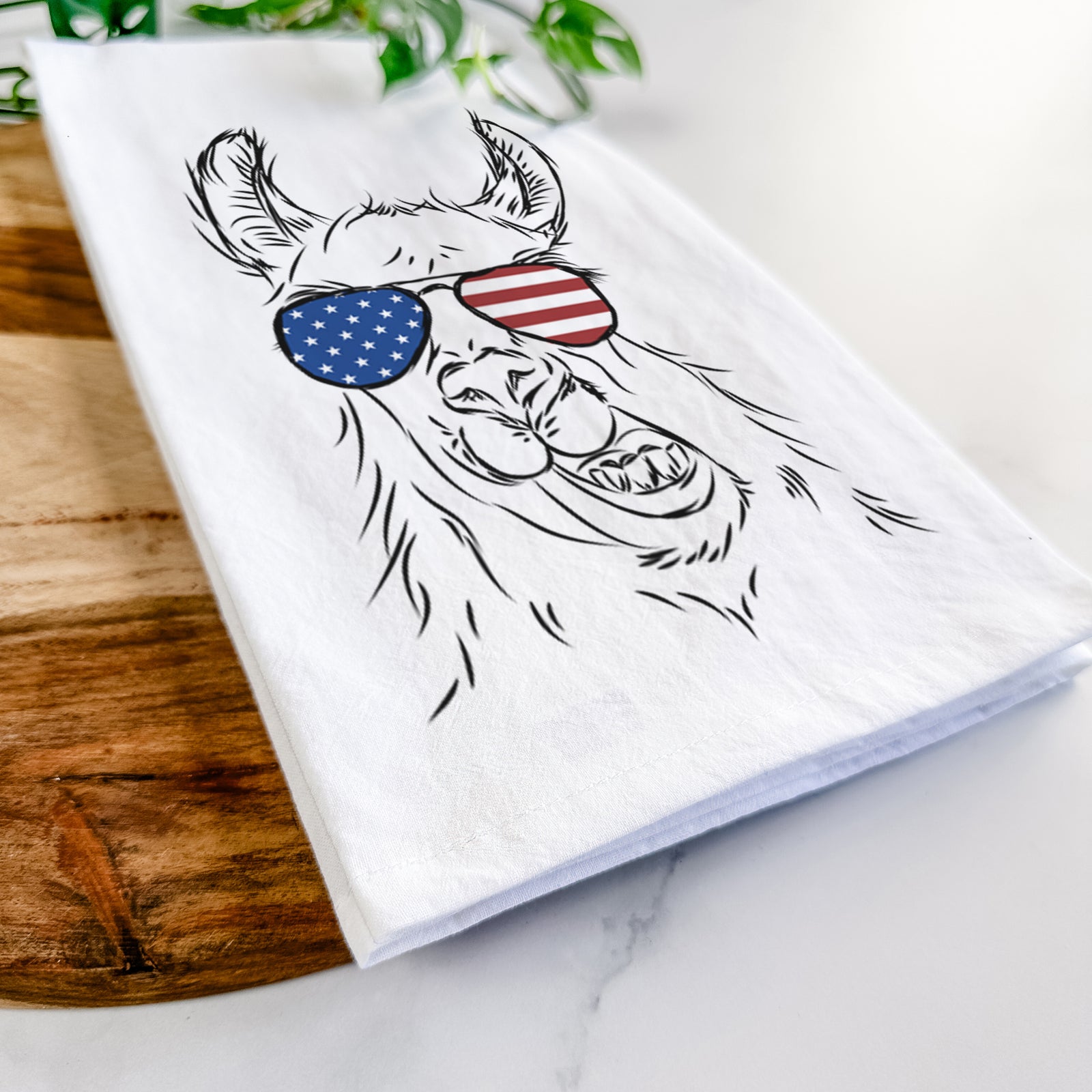 Hand-drawn sketch of Larry the Llama wearing American flag sunglasses on a tea towel
