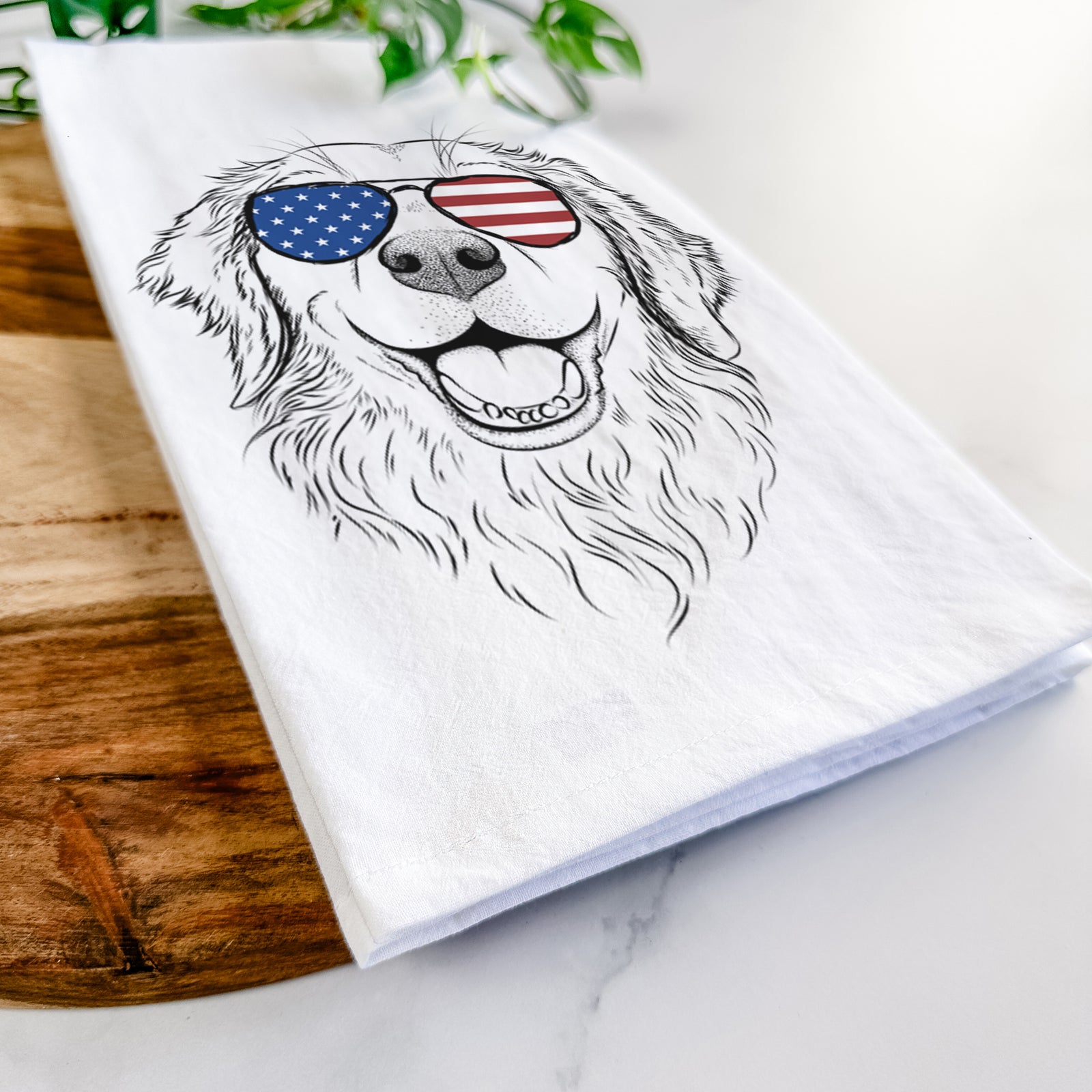 Hand-drawn sketch of Legend the Golden Retriever wearing American flag sunglasses on a tea towel