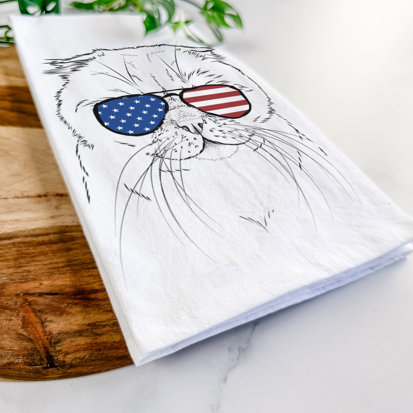 Hand-drawn sketch of Lina the Exotic Fold Cat wearing American flag sunglasses on a tea towel