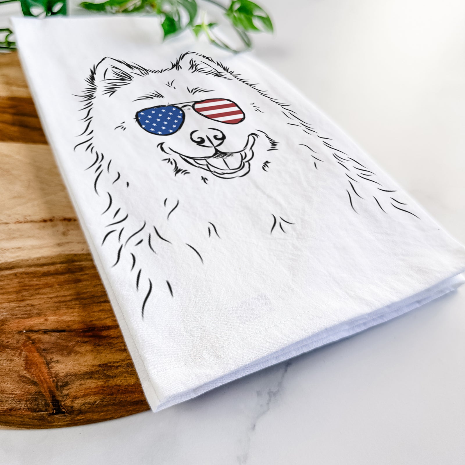 Hand-drawn sketch of Luka the Samoyed wearing American flag sunglasses on a tea towel