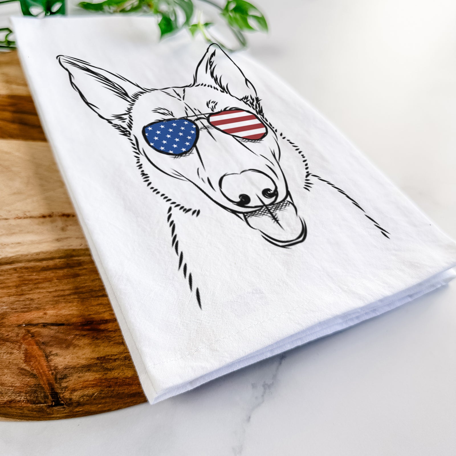 Hand-drawn sketch of Lyric the Belgian Malinois wearing American flag sunglasses on a tea towel