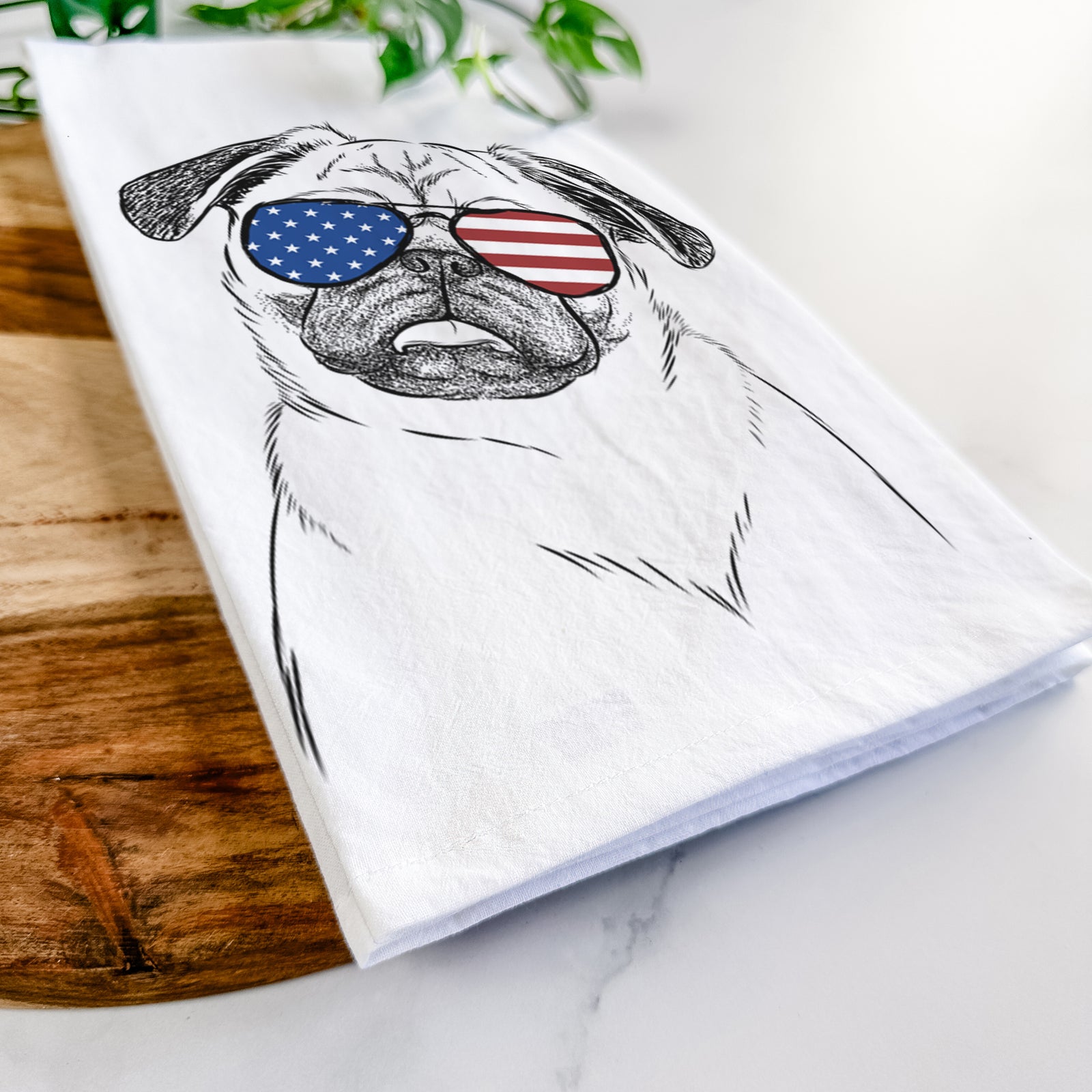 Hand-drawn sketch of Macy the Pug wearing American flag sunglasses on a tea towel